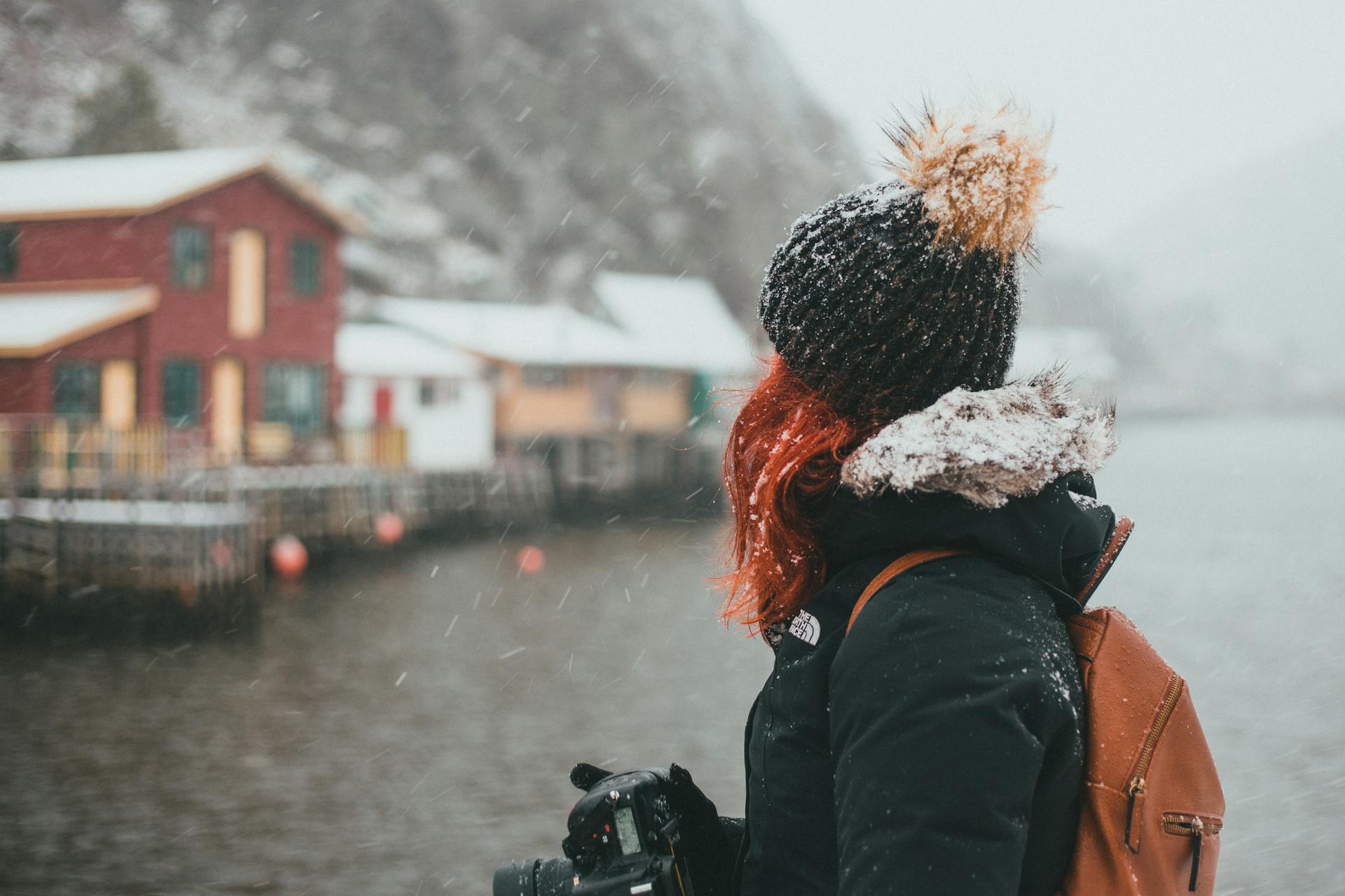 Woman in Black Jacket and White Knit Cap Holding Black Dslr Camera