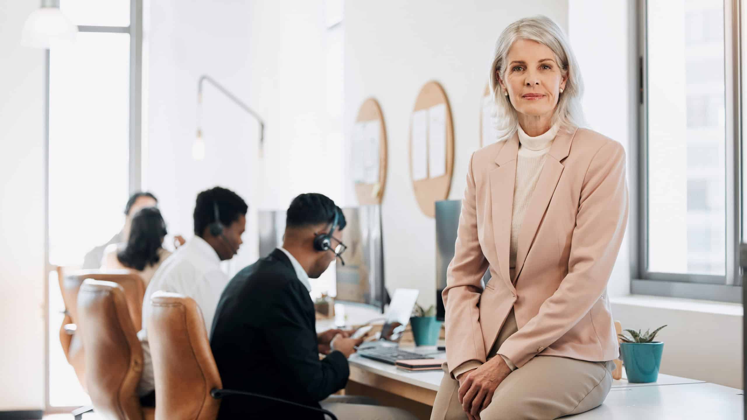 Theres no micromanaging around here. a mature businesswoman sitting in the office while her team work behind her.