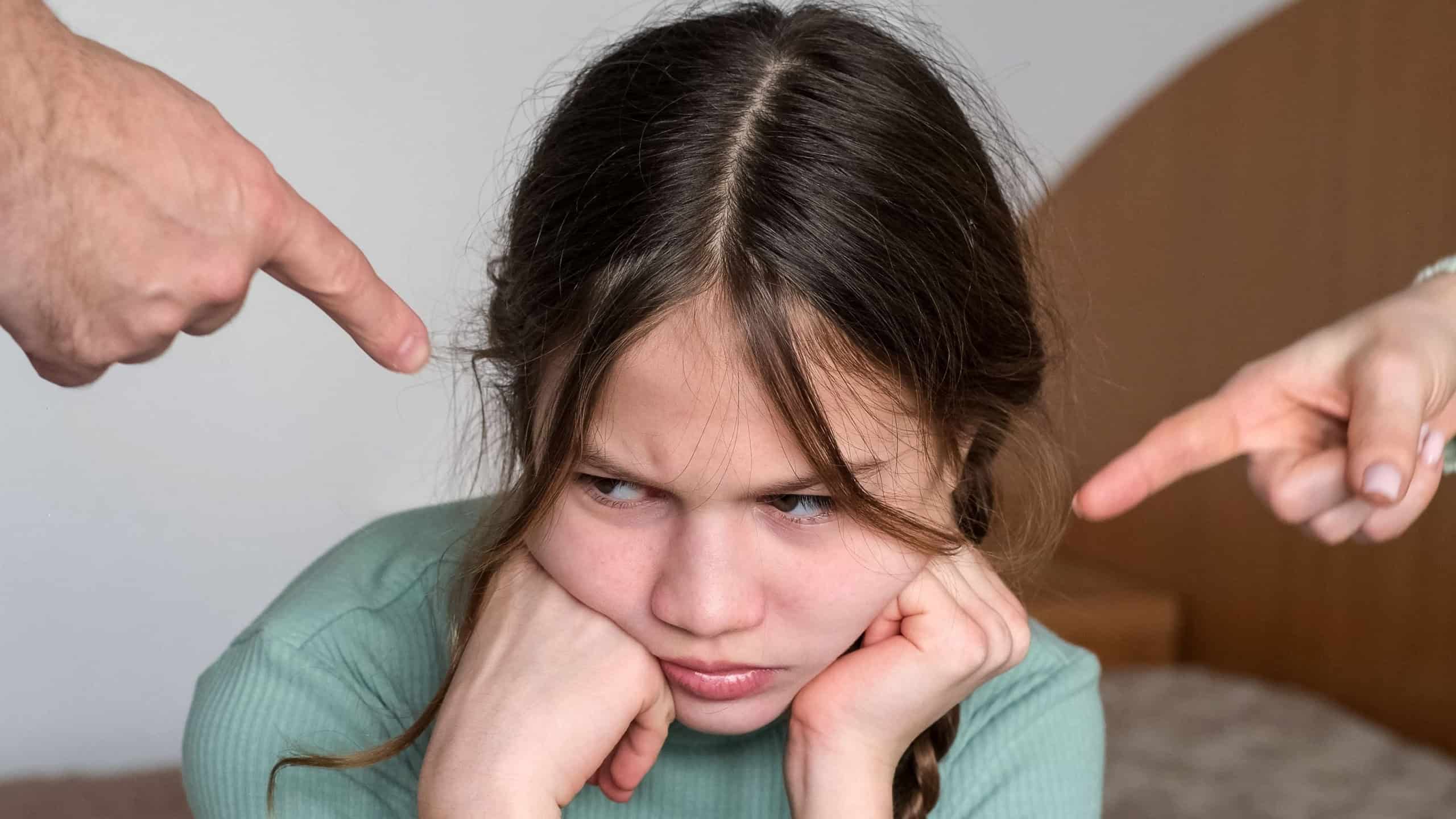 Parents scolding little girl at home. Sad child ignoring them. Kid having bad mood and feeling upset. Family conflict