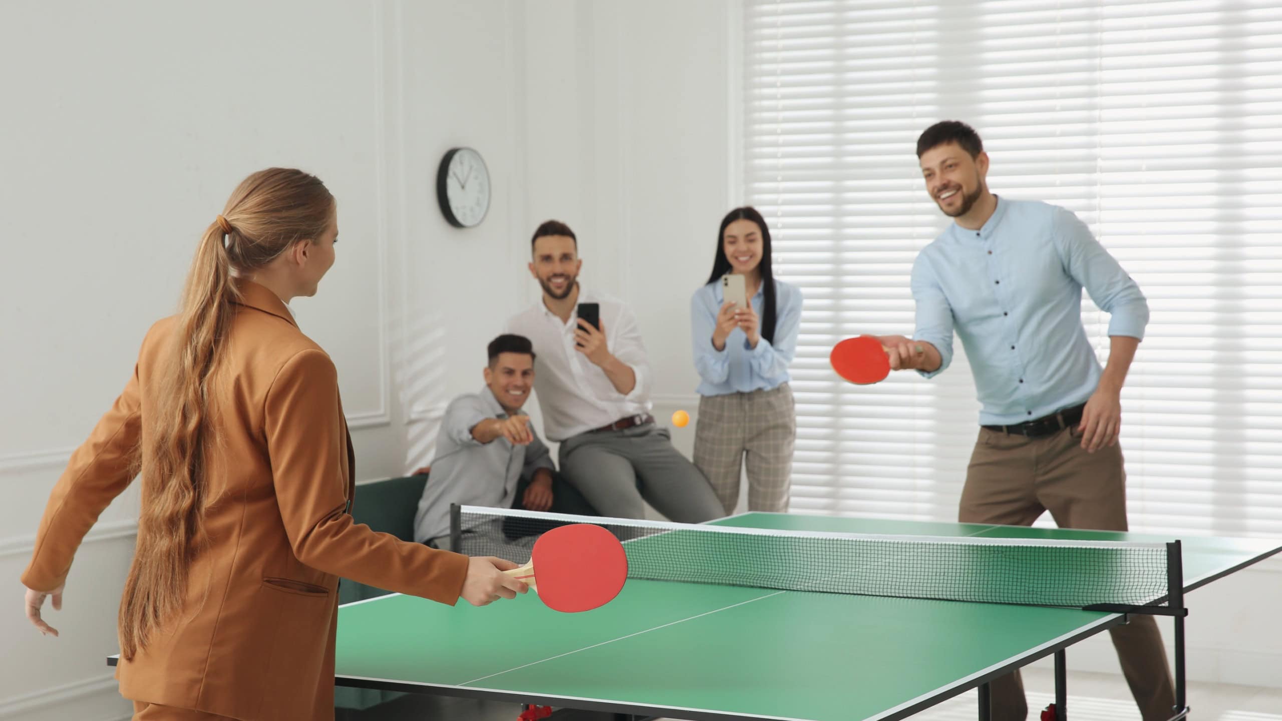 Business people playing ping pong in office