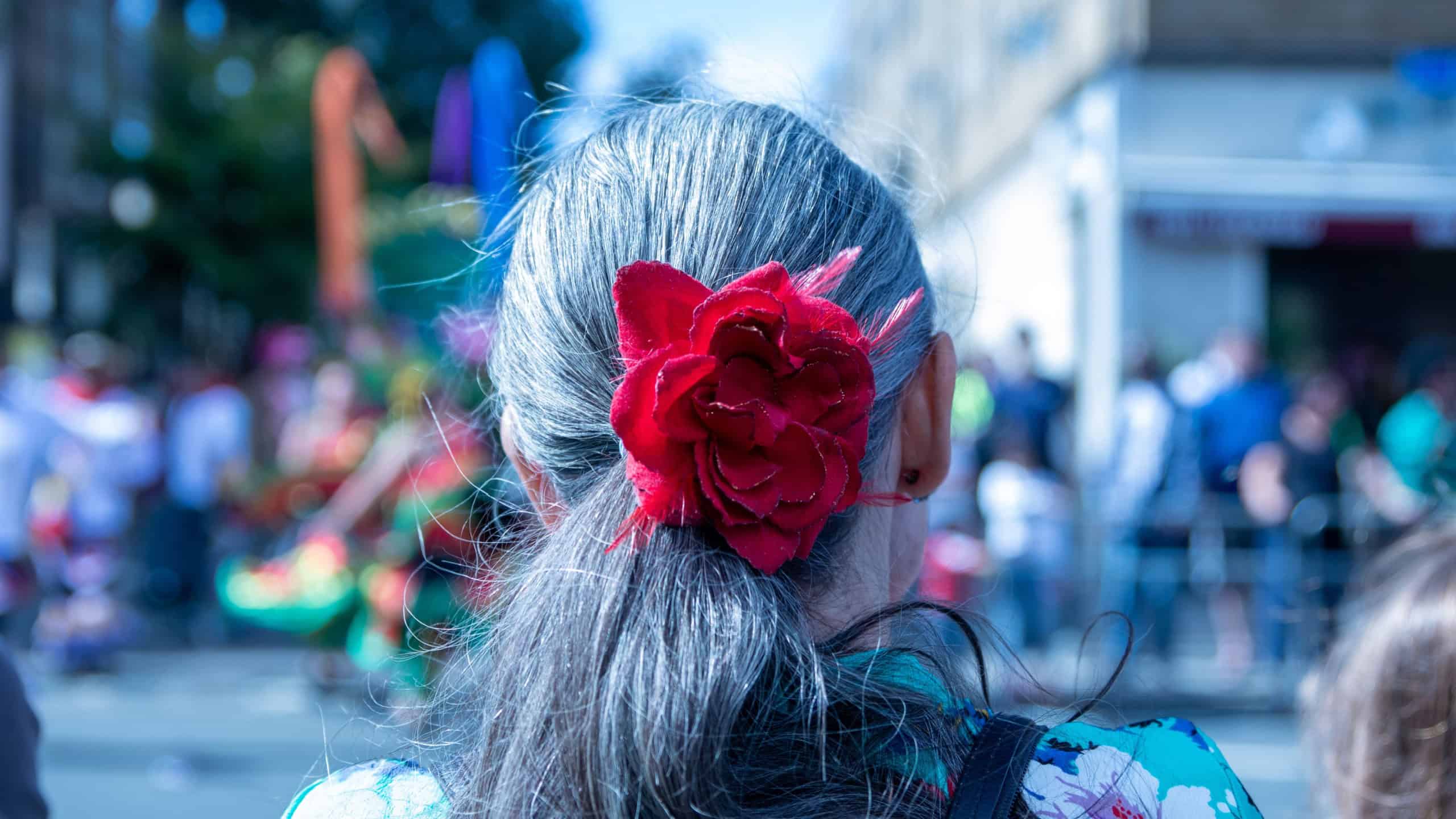 LONDON, UNITED KINGDOM - Sep 08, 2021: A back view of a senior female with a red flower hairband at the Hackney Carnival in London, UK