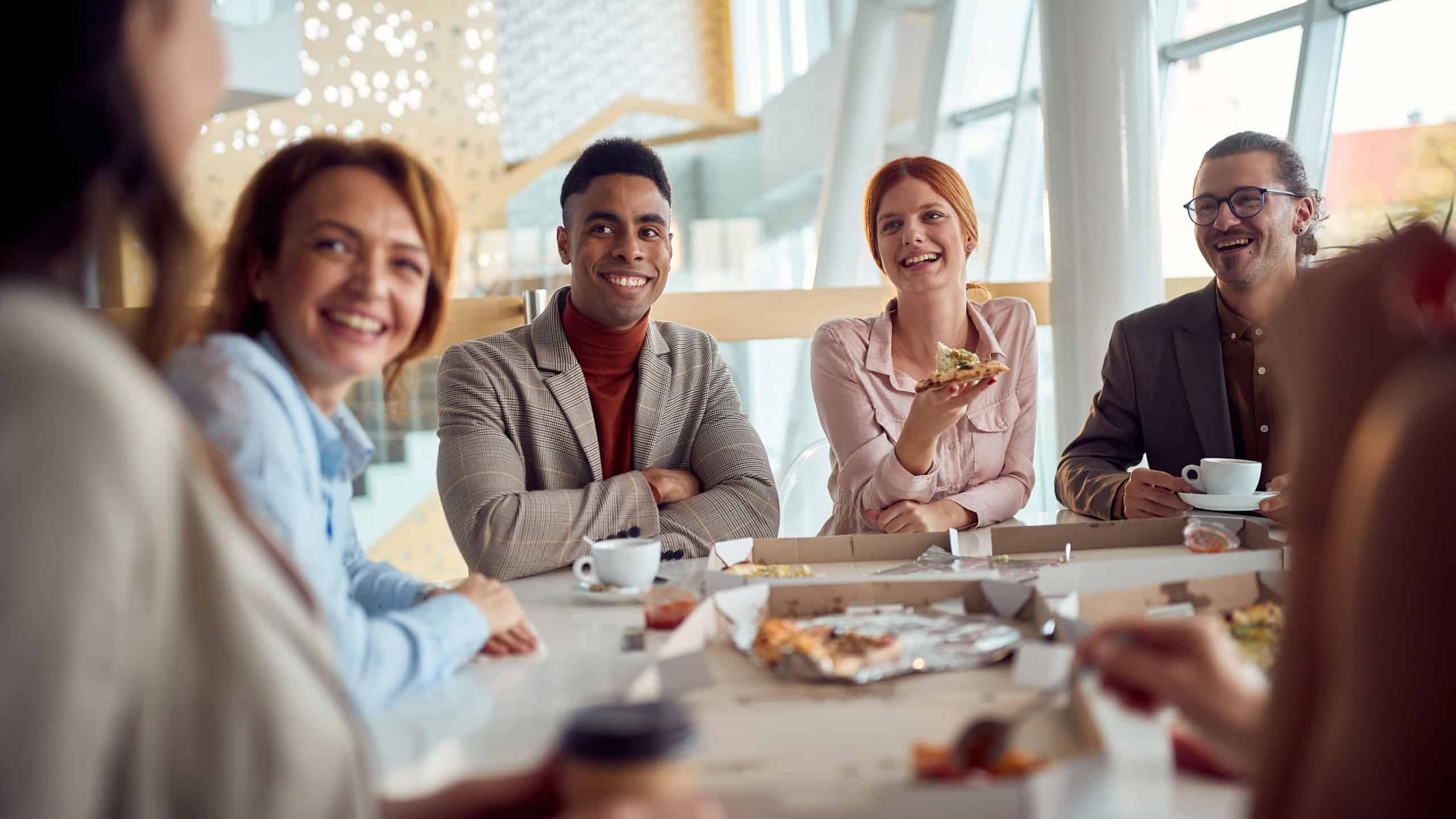 Young business team has a friendly talk during a lunch break in a pleasant atmosphere in the company building. Business, people, company