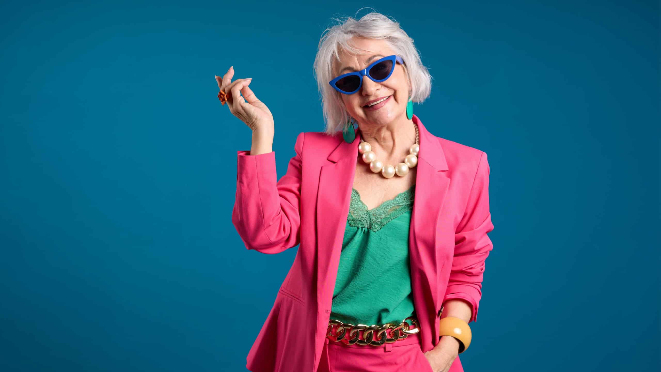 Fashionable Senior Lady Posing in Trendy Sunglasses and Pink Blazer