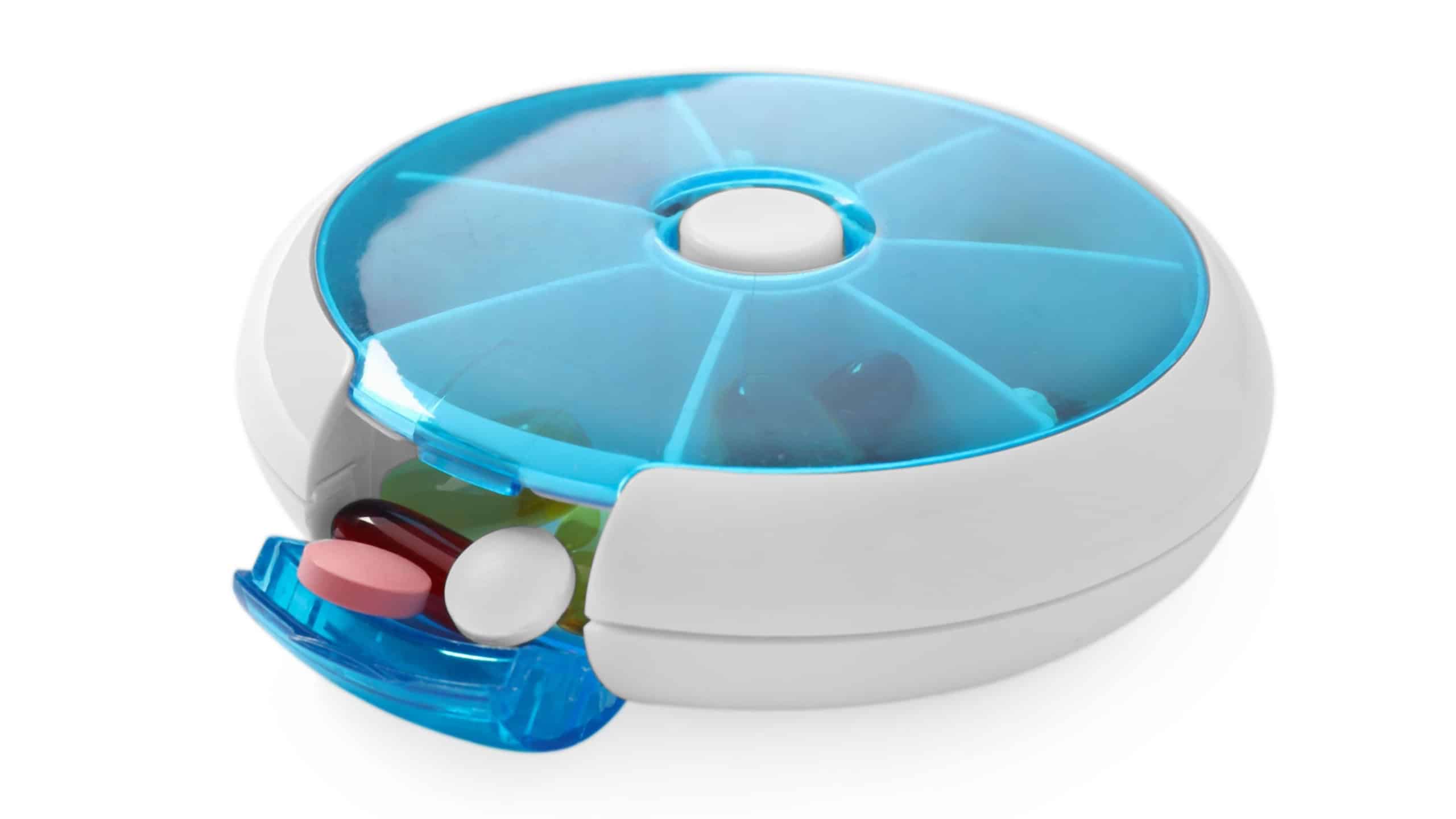 Different pills in organizer isolated on white