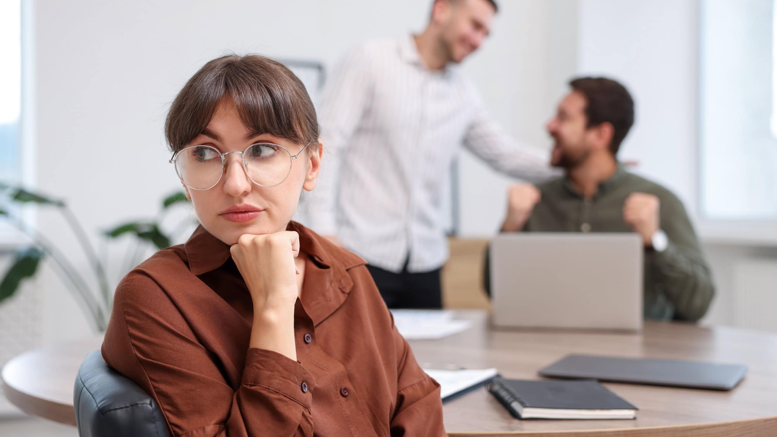 Woman feeling jealous of her colleague's success in office, selective focus