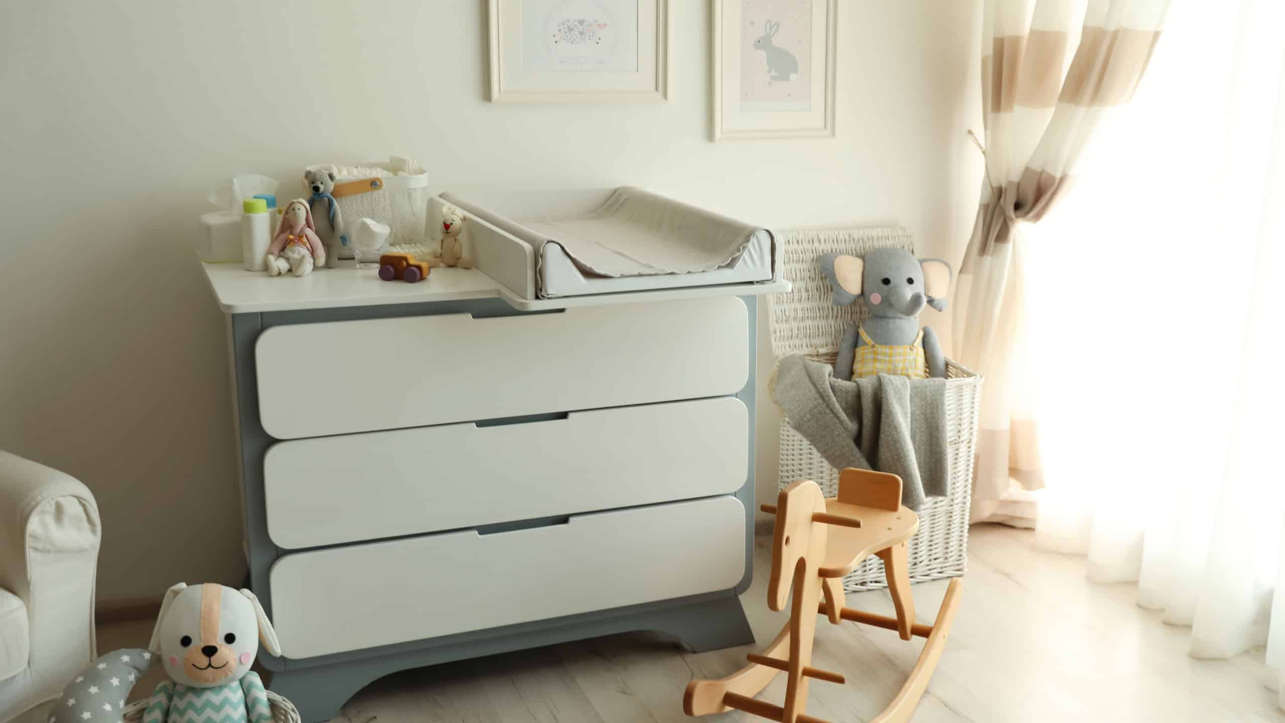 Beautiful baby room interior with toys and modern changing table