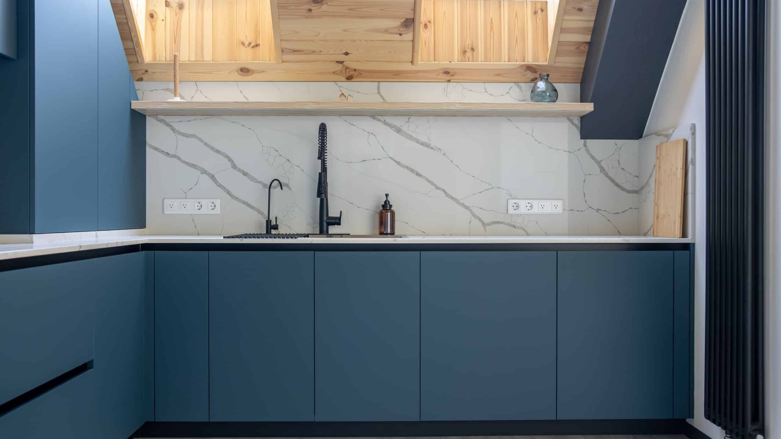 Modern attic kitchen. Minimalist interior. Blue matte cabinets.