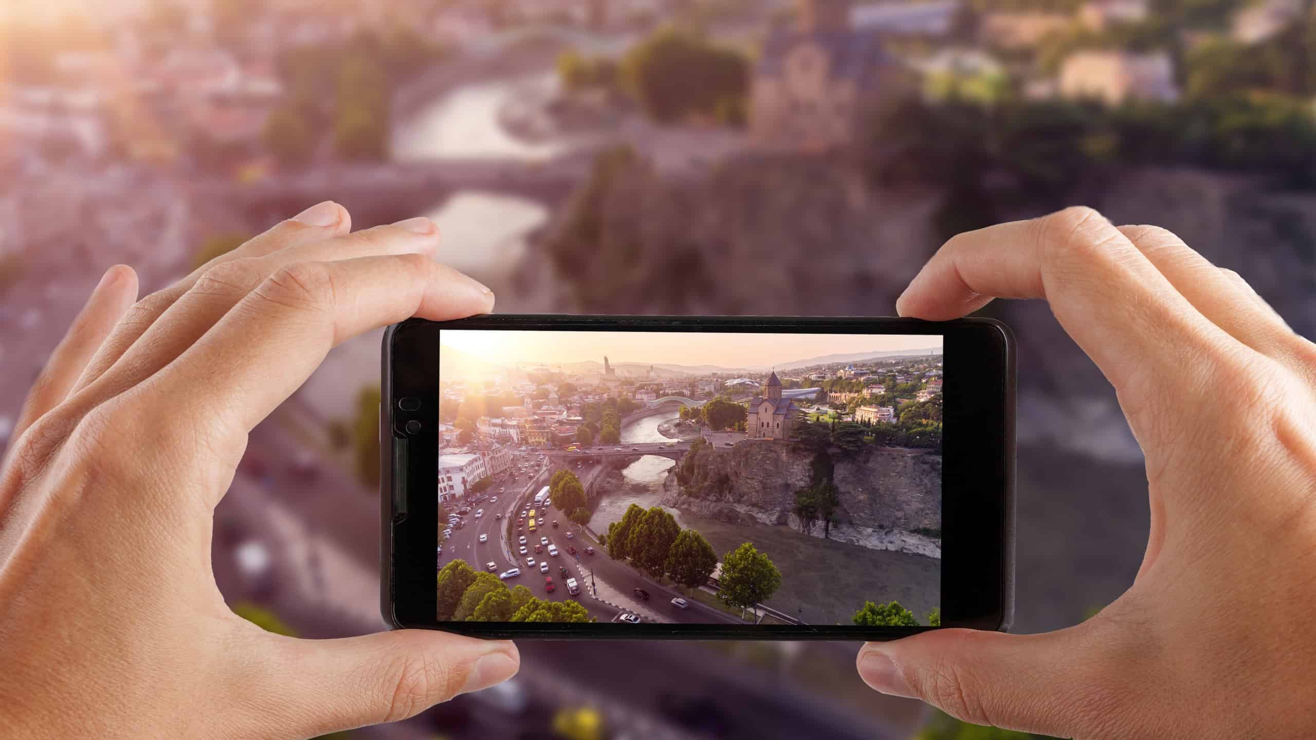 Travel concept. Hands making photo of TBILISI capital of Georgia.