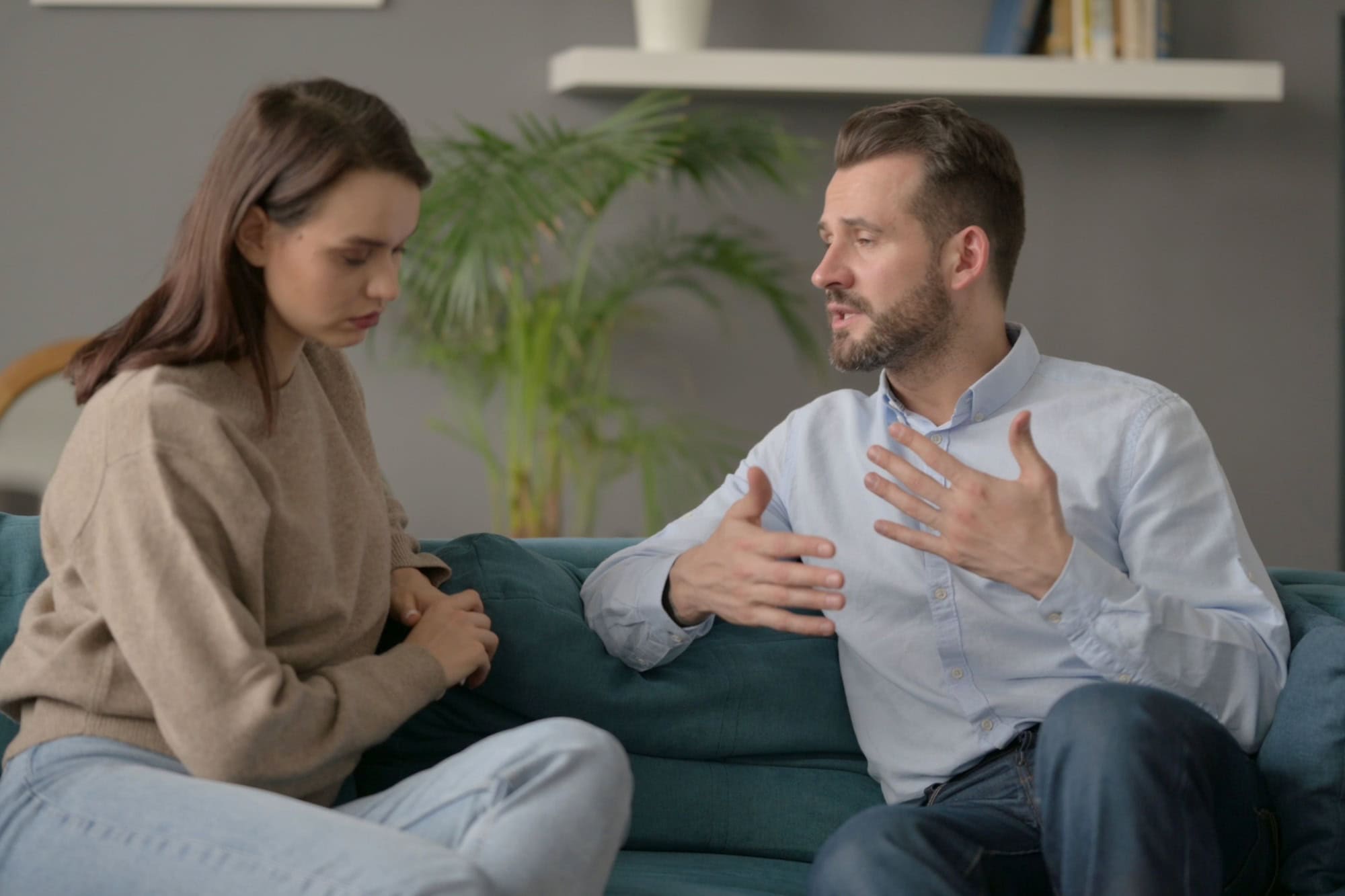 Serious Man Talking to Woman While Sitting on Sofa