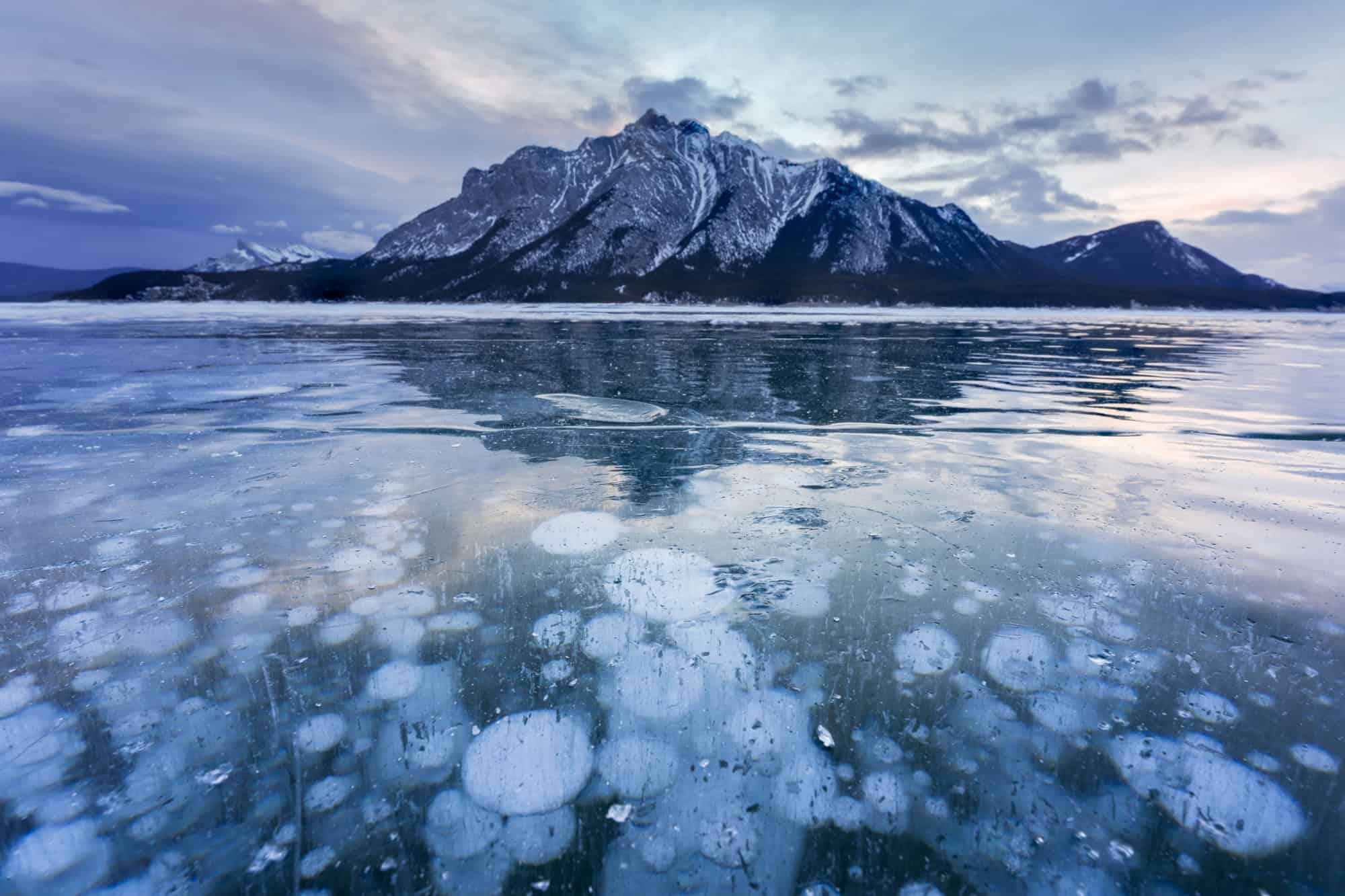 Beautiful view of Frozen Abraham Lake with rocky mountains and natural bubbles frost in the morning on winter at Banff national park, Alberta, Canada