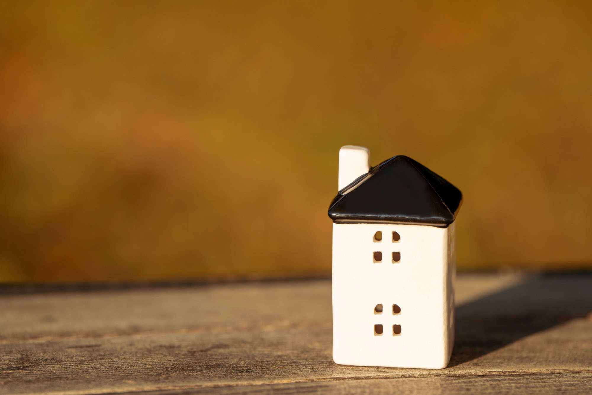 A small house stands on a bench in the park. Real estate, affordable housing and mortgage lending concept. Sale, purchase and rental of apartments