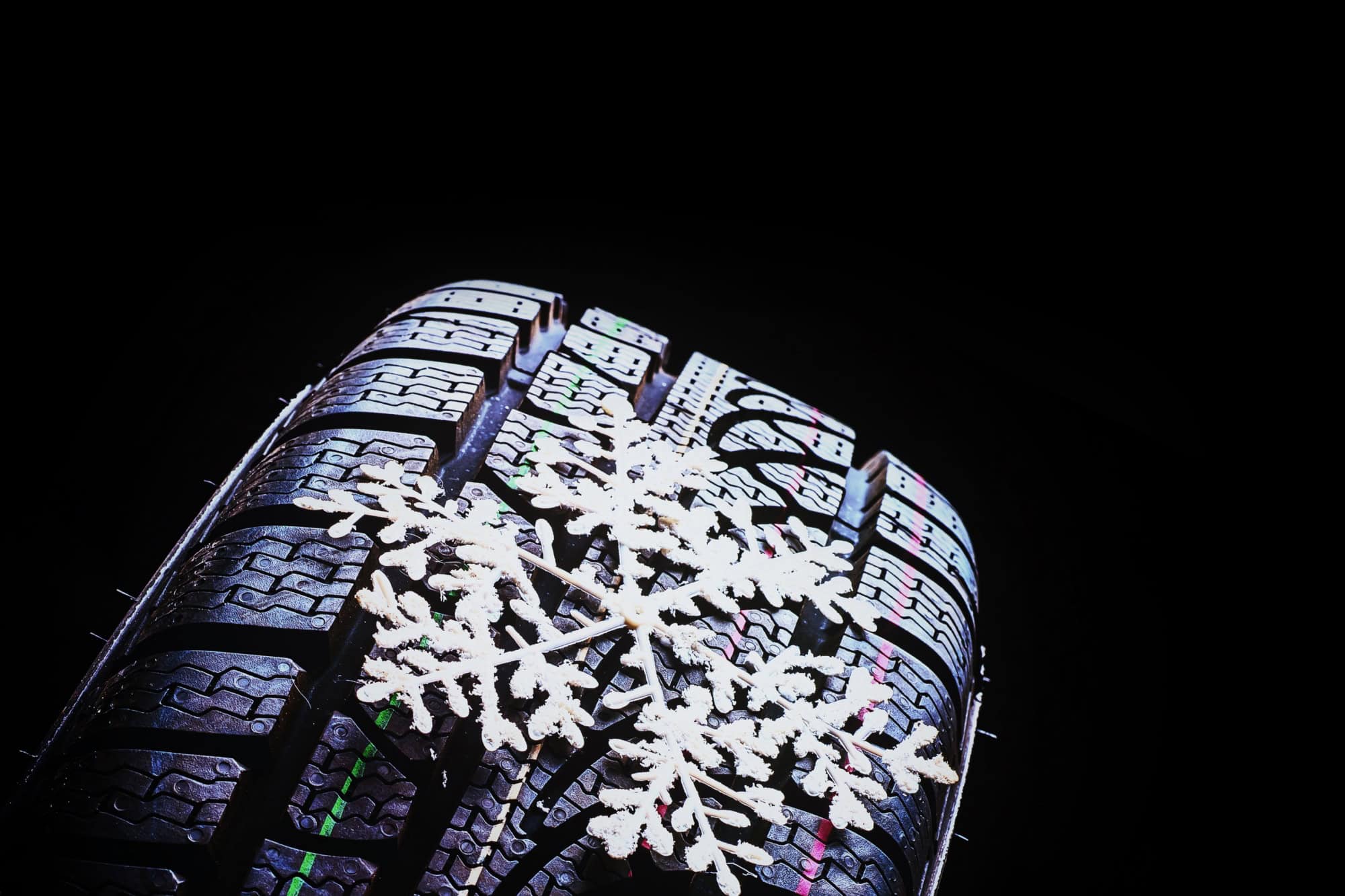 Winter tires on black background