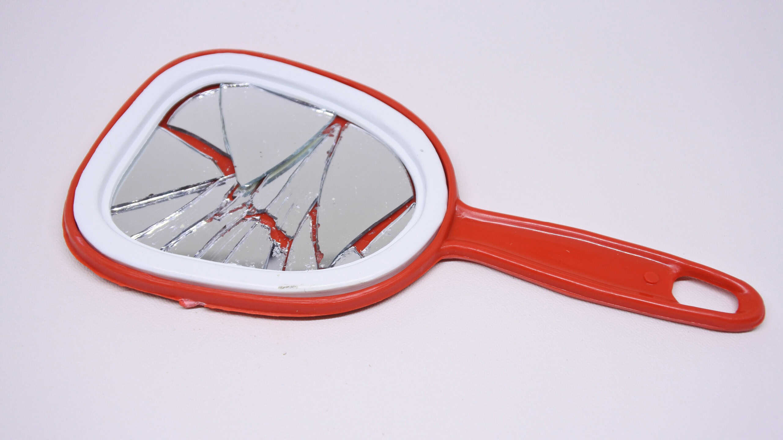 Broken mirror on white background