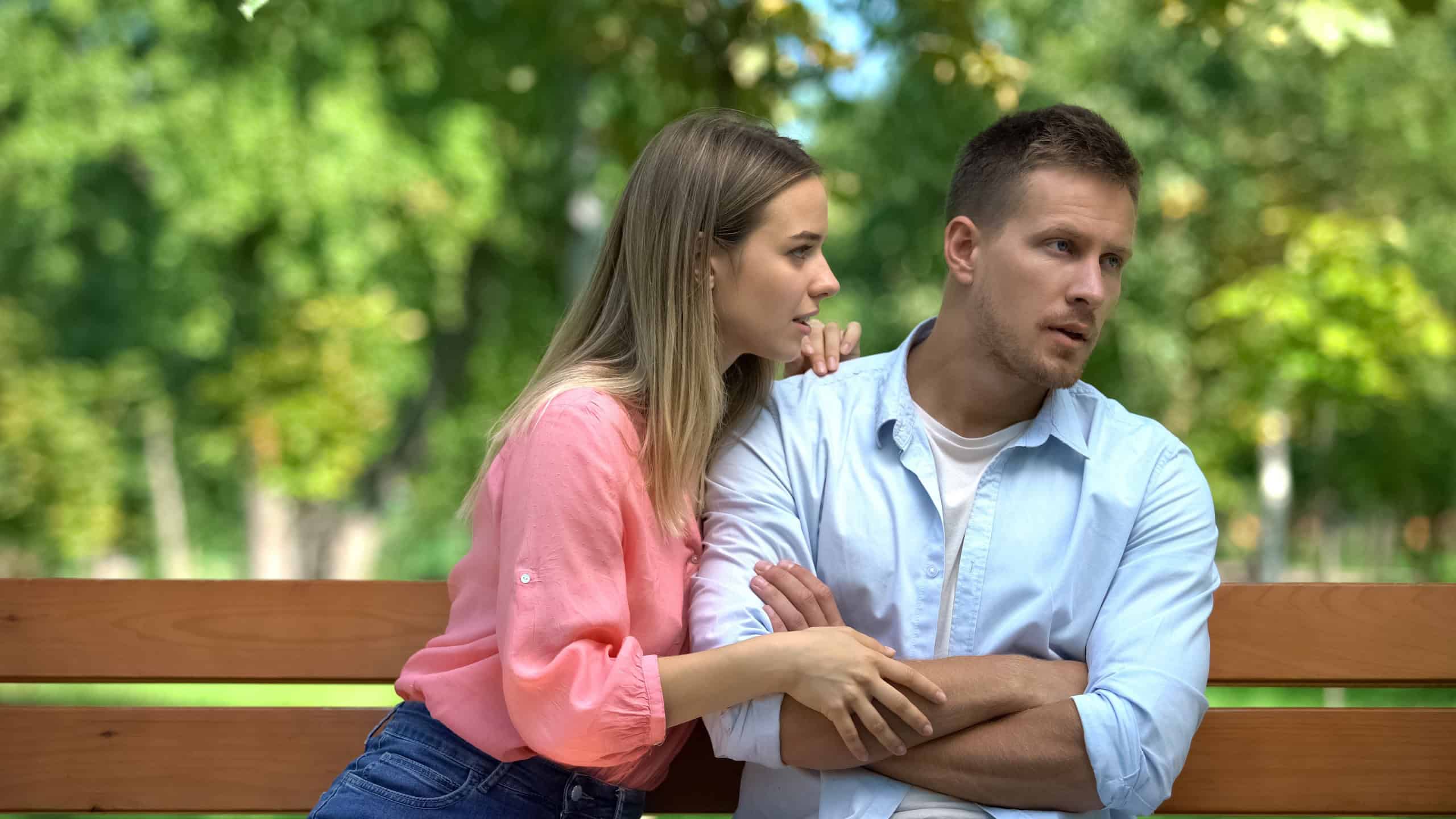 Apologizing woman hugging offended man, reconciliation attempt, couple conflict