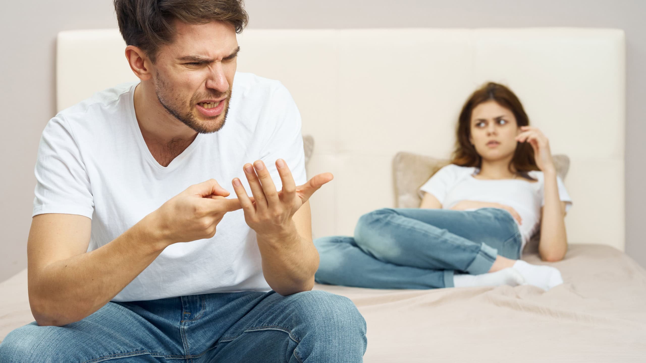 Married couple in the bedroom displeasure conflict quarrel