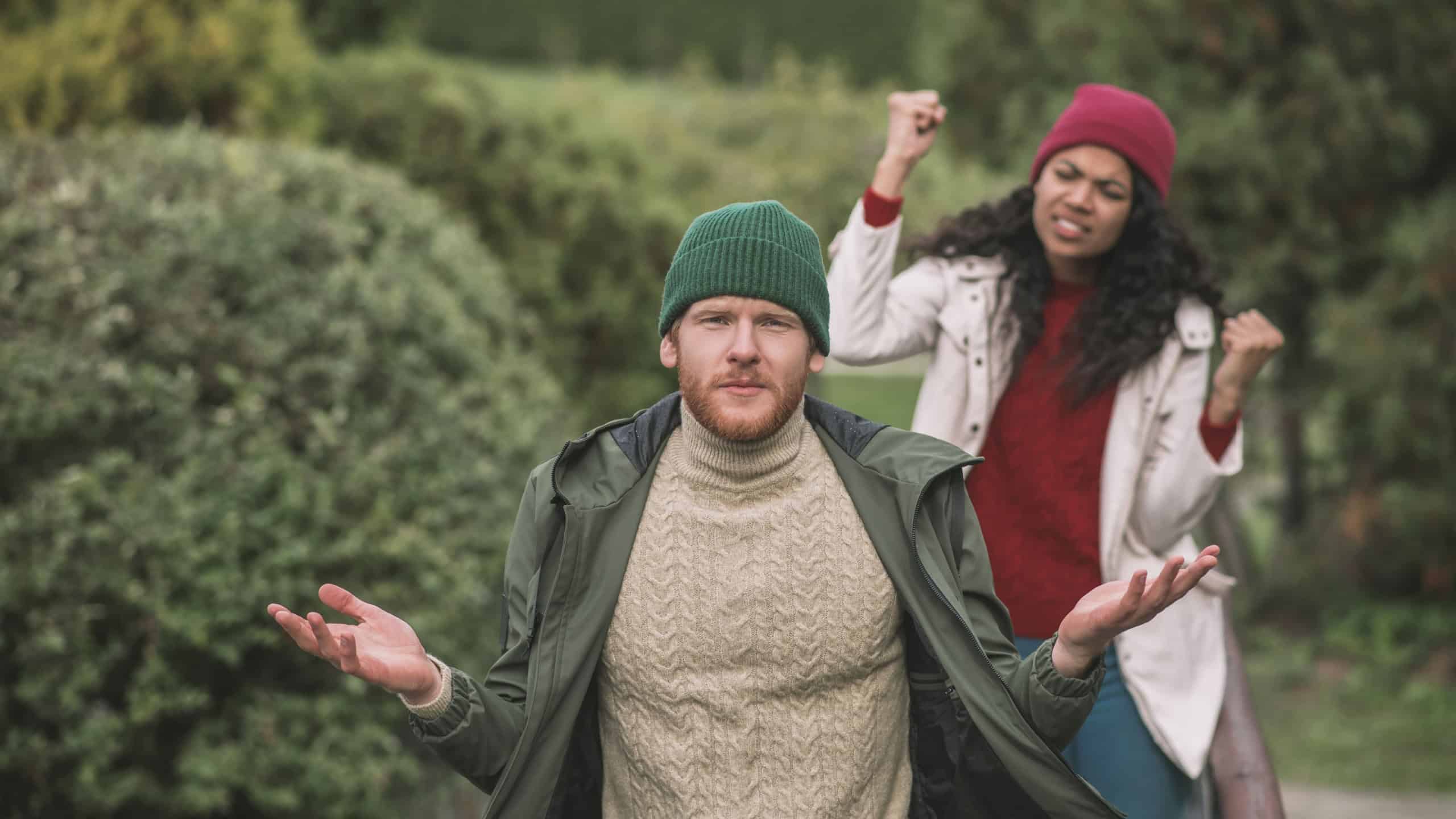 Family argument. A man shrugging while his girlfriend shouts