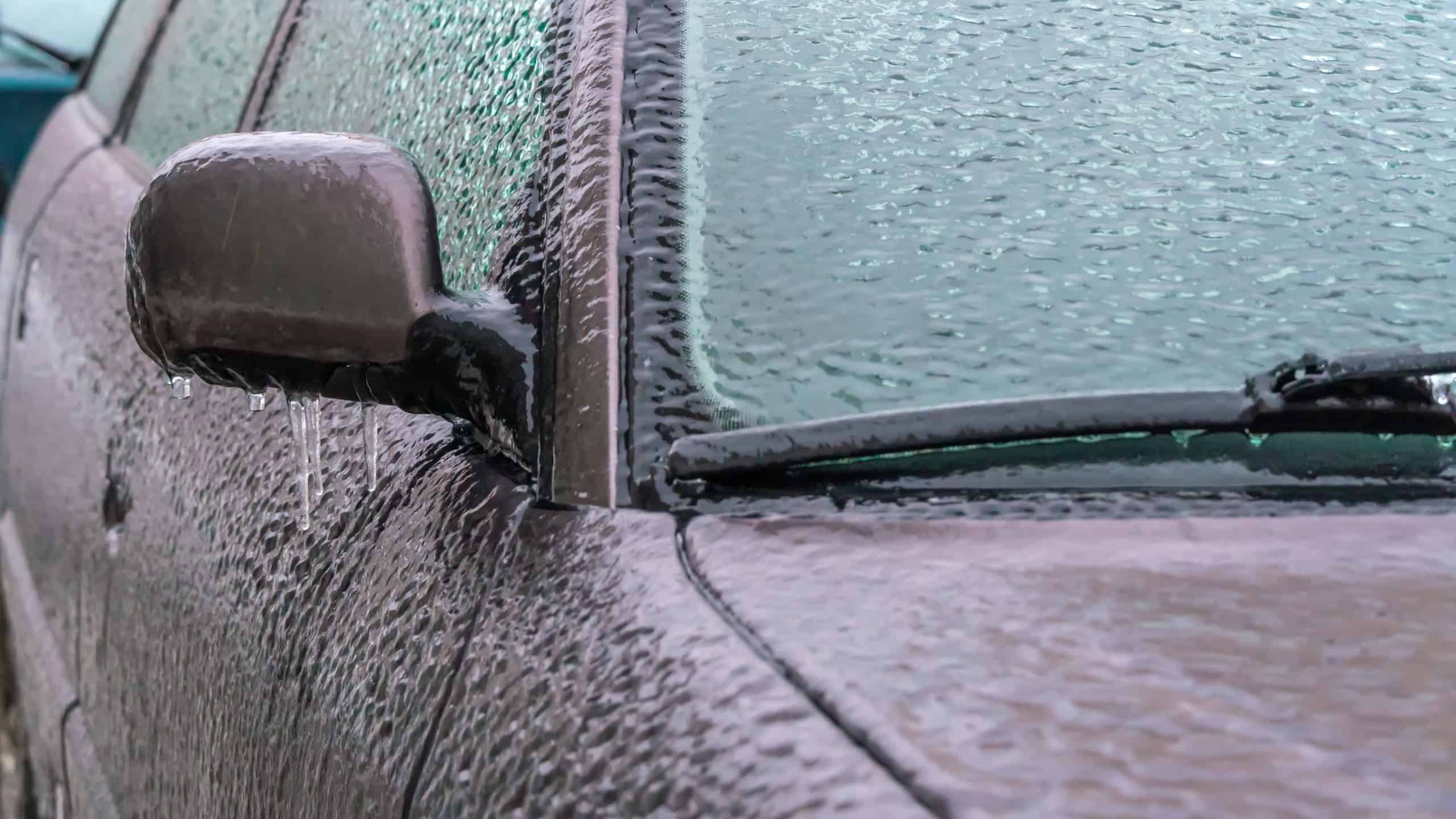 Icy car rearview mirror, windshield, car with icicles, ice close-up. Frozen car