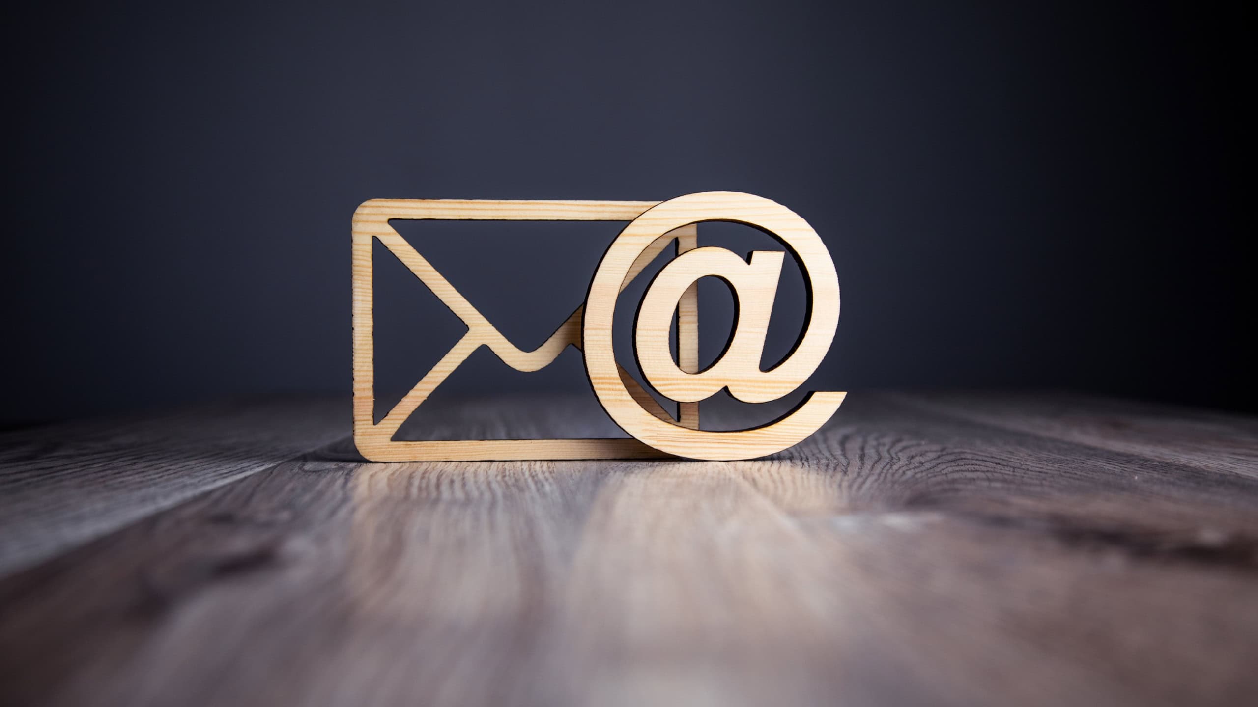 Wooden email with letter symbol on table