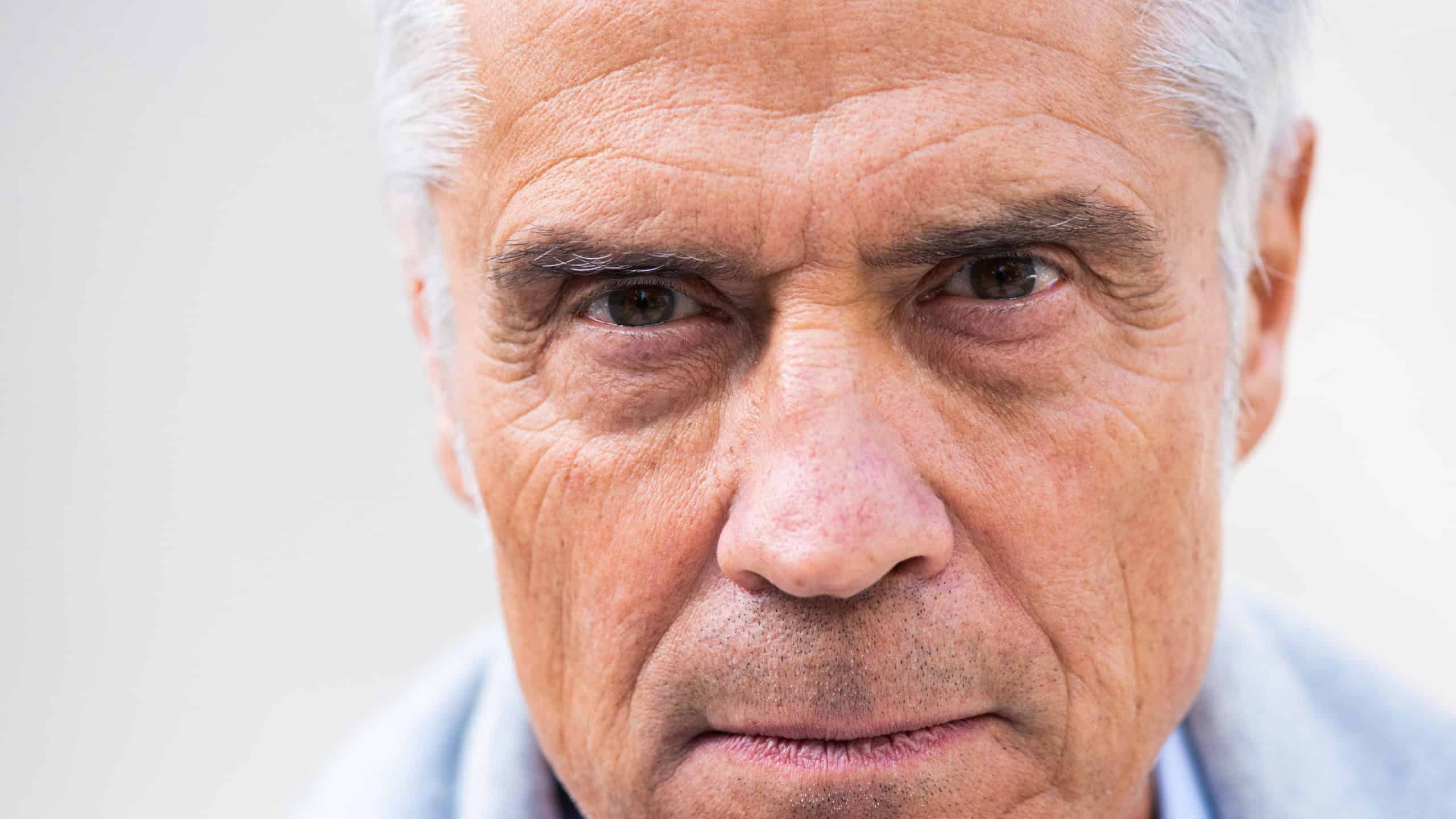 Close up portrait older man head with eyes staring