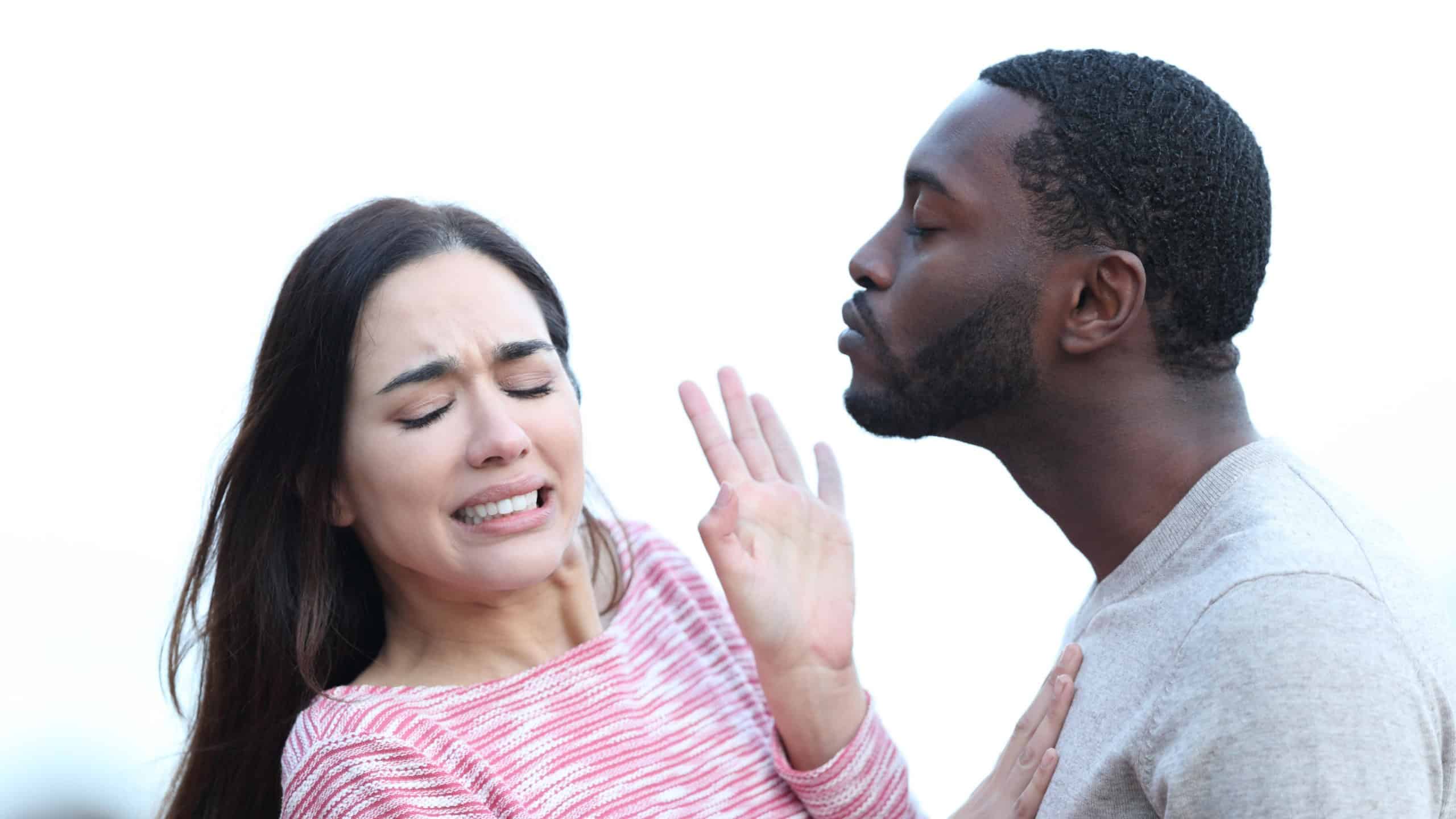 Disgusted woman rejecting a man who is trying to kiss her