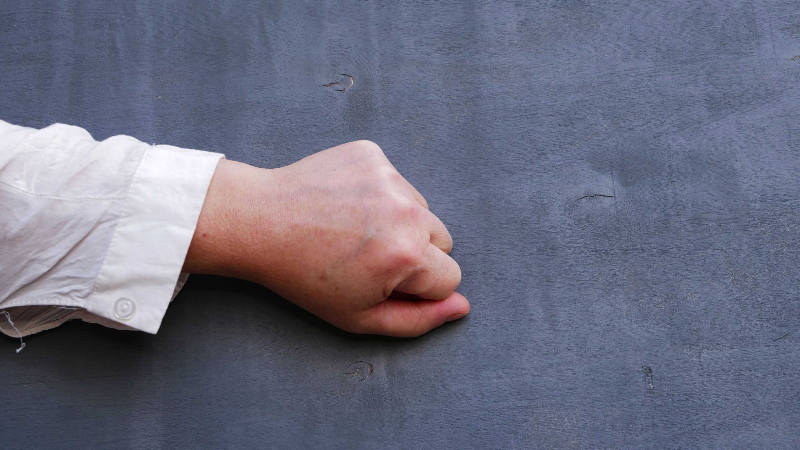 Hand knocking on gray background medium shot selective focus