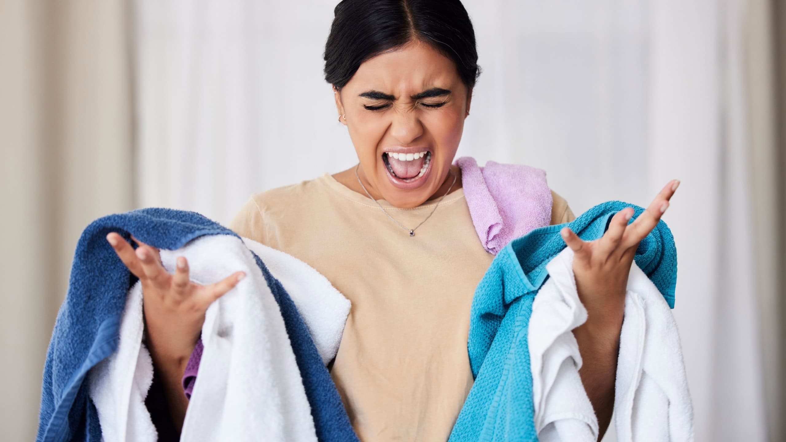 Laundry, frustrated and woman with anger, screaming and overworked with spring cleaning, chores and hygiene. Female, cleaner and maid angry, upset and washing material with burnout or fatigue in home