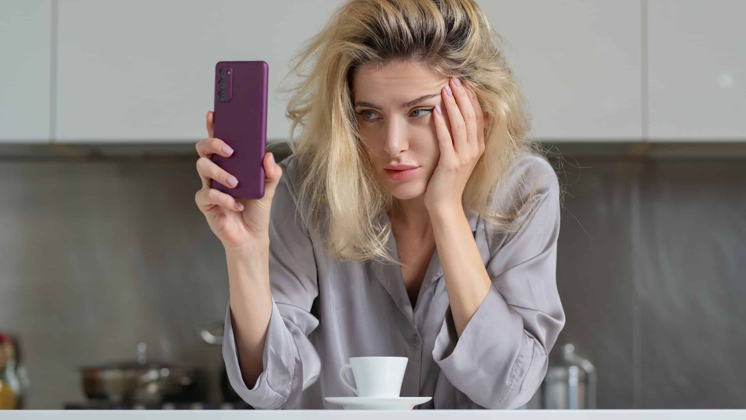 Woman looking annoyed at her phone