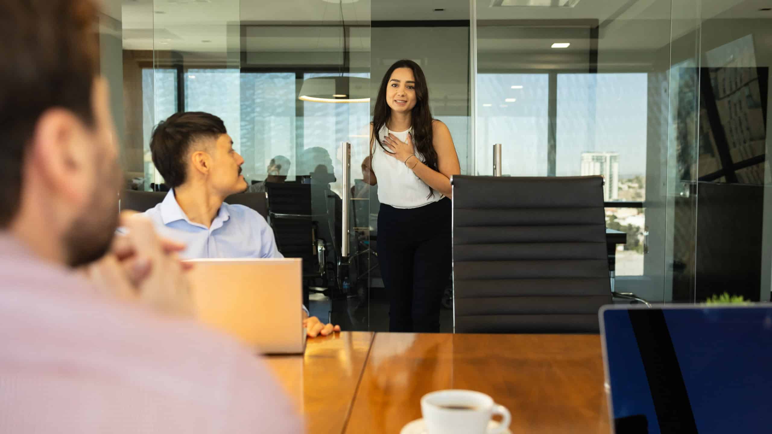 Beautiful woman arriving late to a meeting at work and asking for permission to come