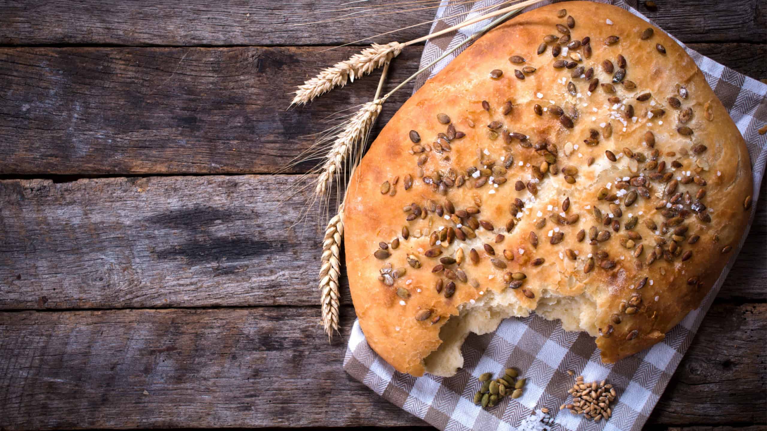 Homemade bannock with pumpkin seed from above on wooden background with blank space