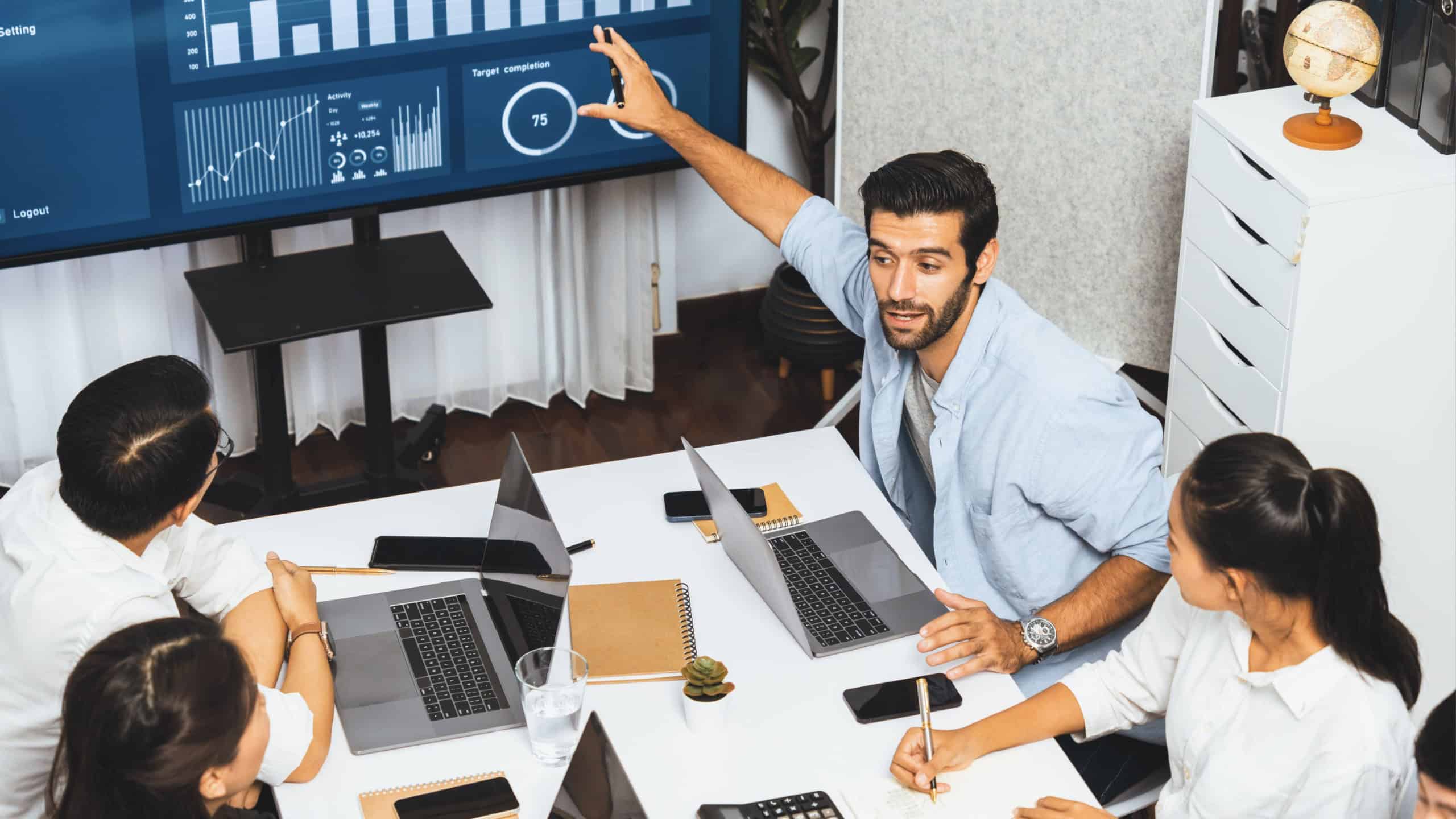 Analyst team utilizing BI Fintech to analyze financial data at table in meeting room. Businesspeople analyzing BI dashboard power for business insight and strategic marketing planning.