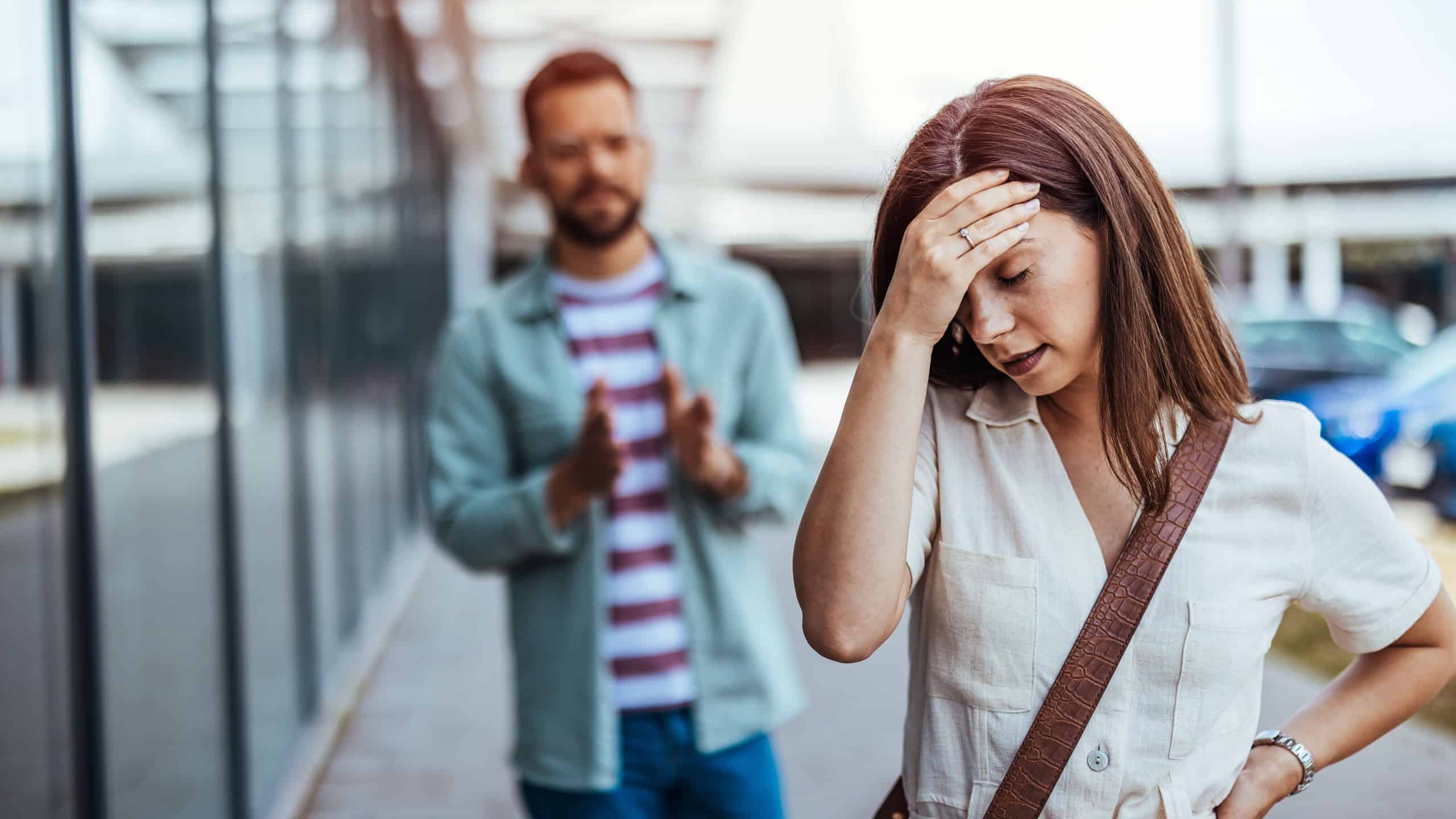 An emotional scene featuring a woman visibly upset, walking away while a man gestures apologetically. Captures the struggle of resolving personal disagreements and the emotions of conflict.