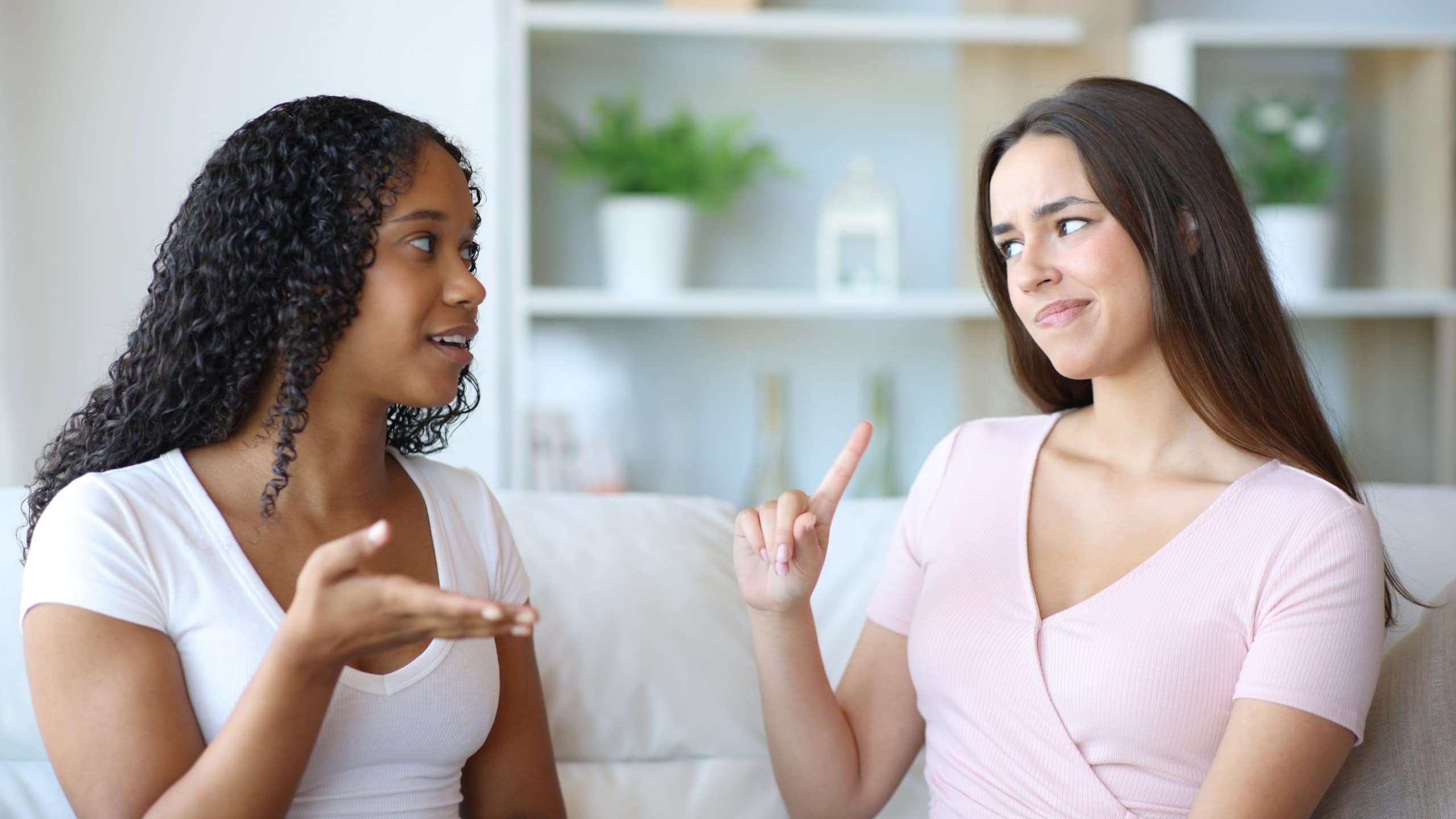 Black woman talking and her friend saying no with the finger at home
