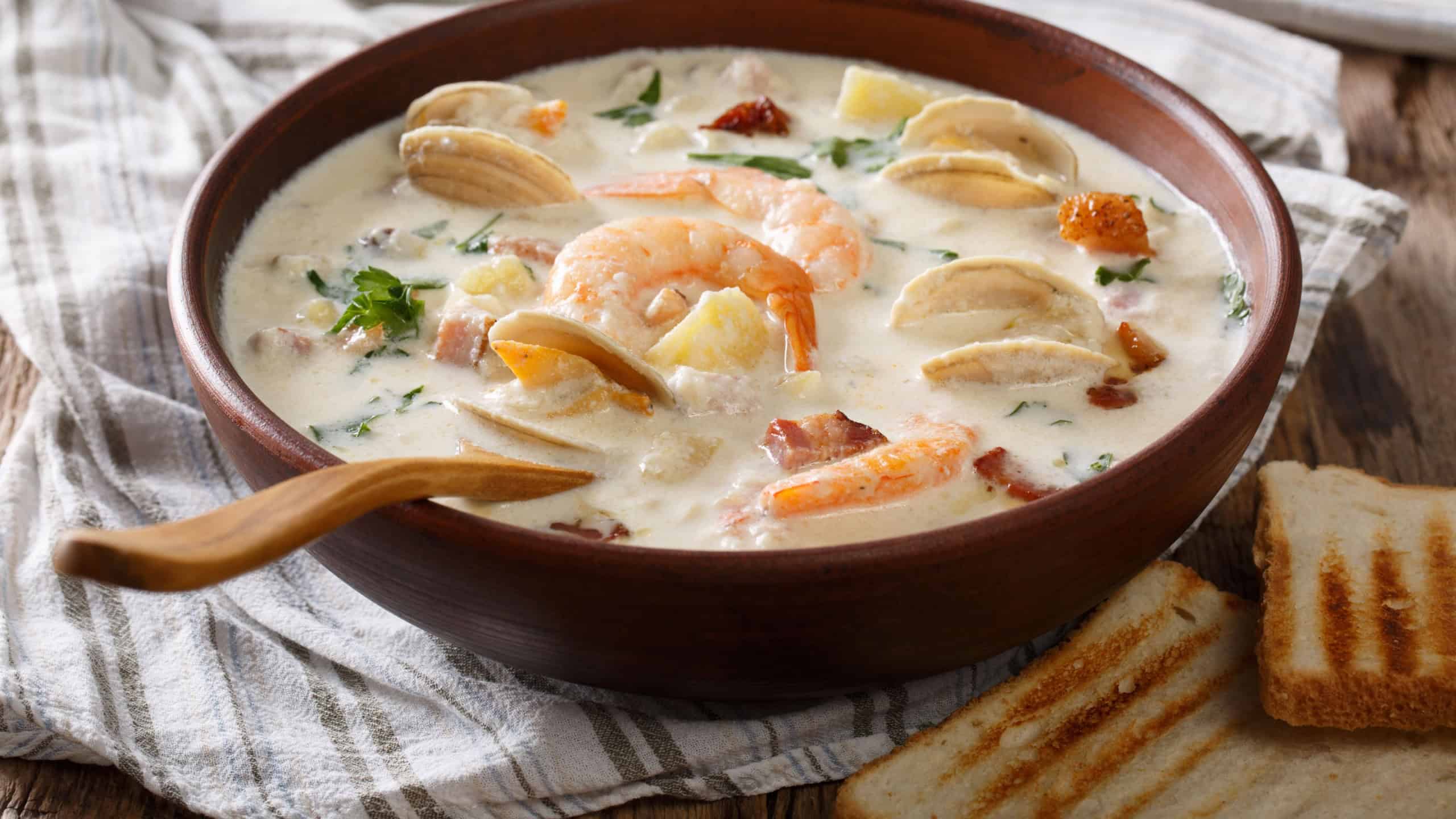 Thick milky Clam chowder soup close-up in a bowl.