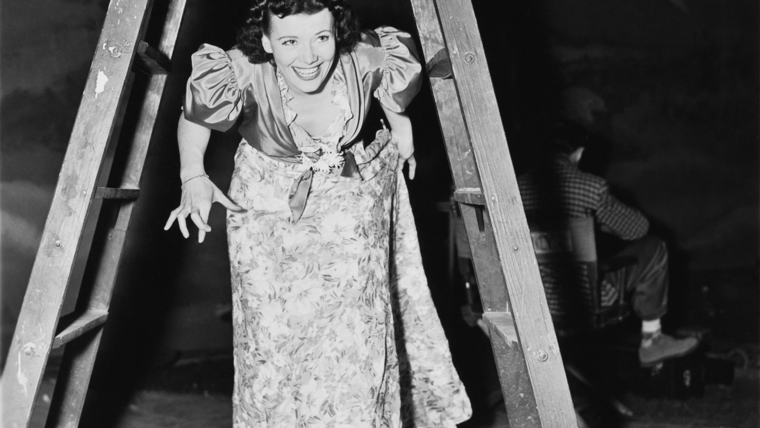 Woman walking under a step ladder with her fingers crossed