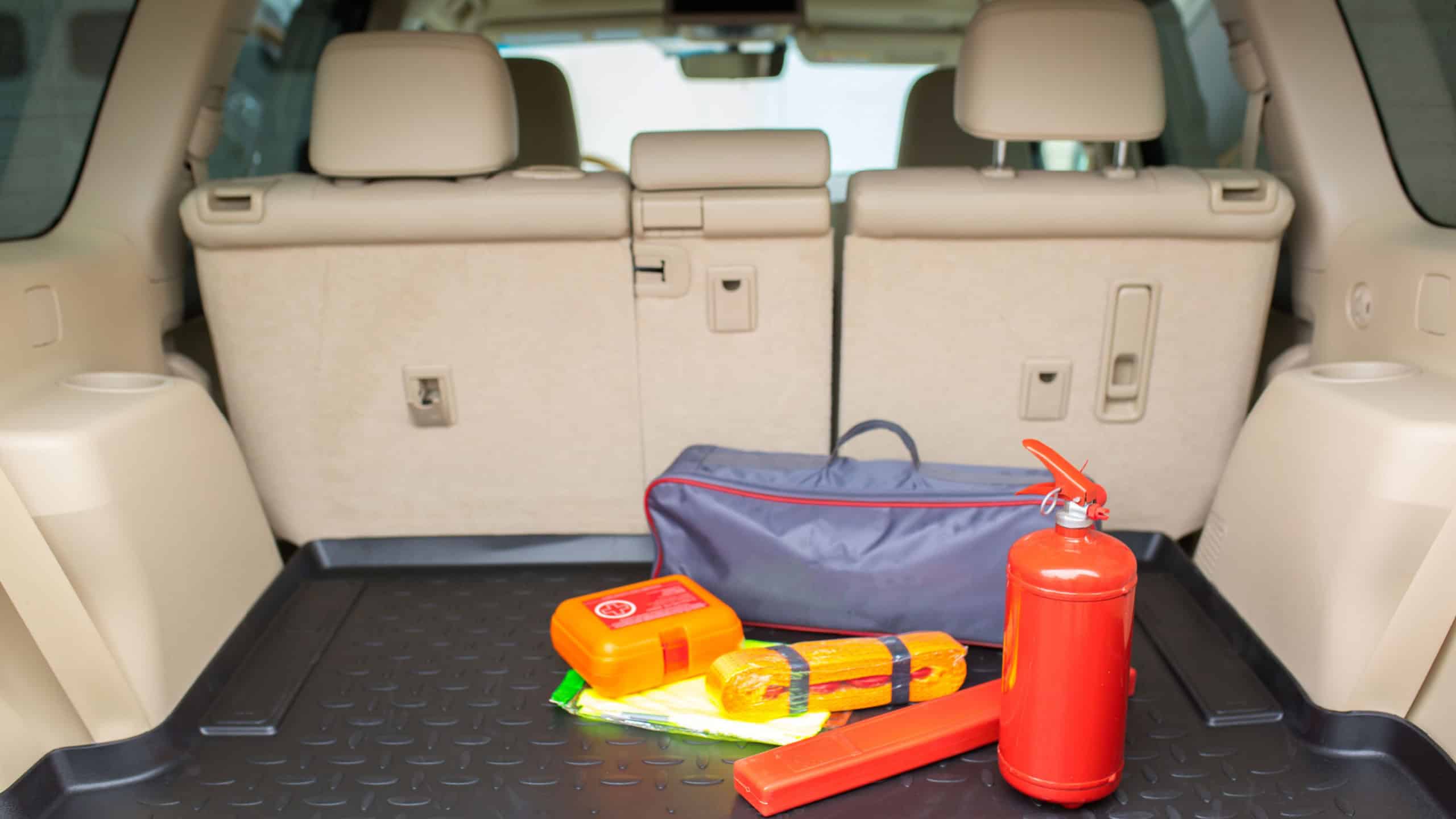 Set for a car from a fire extinguisher, tow rope, tool kit and medical kit in the trunk of an off-road vehicle.
