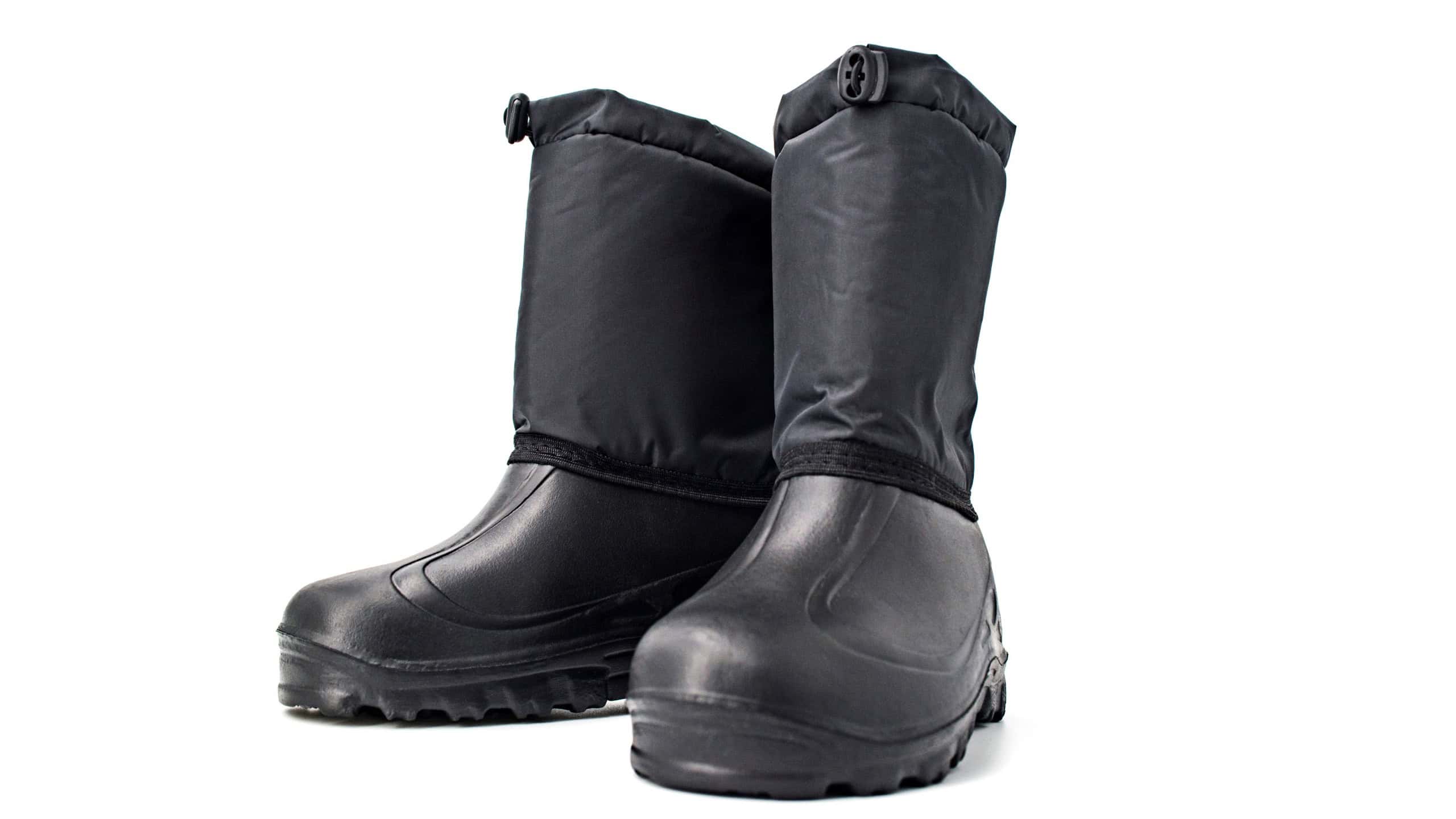 Black high insulated specialized boots for hunting off-road fishing and traveling in the cold season on a white background isolate close-up.