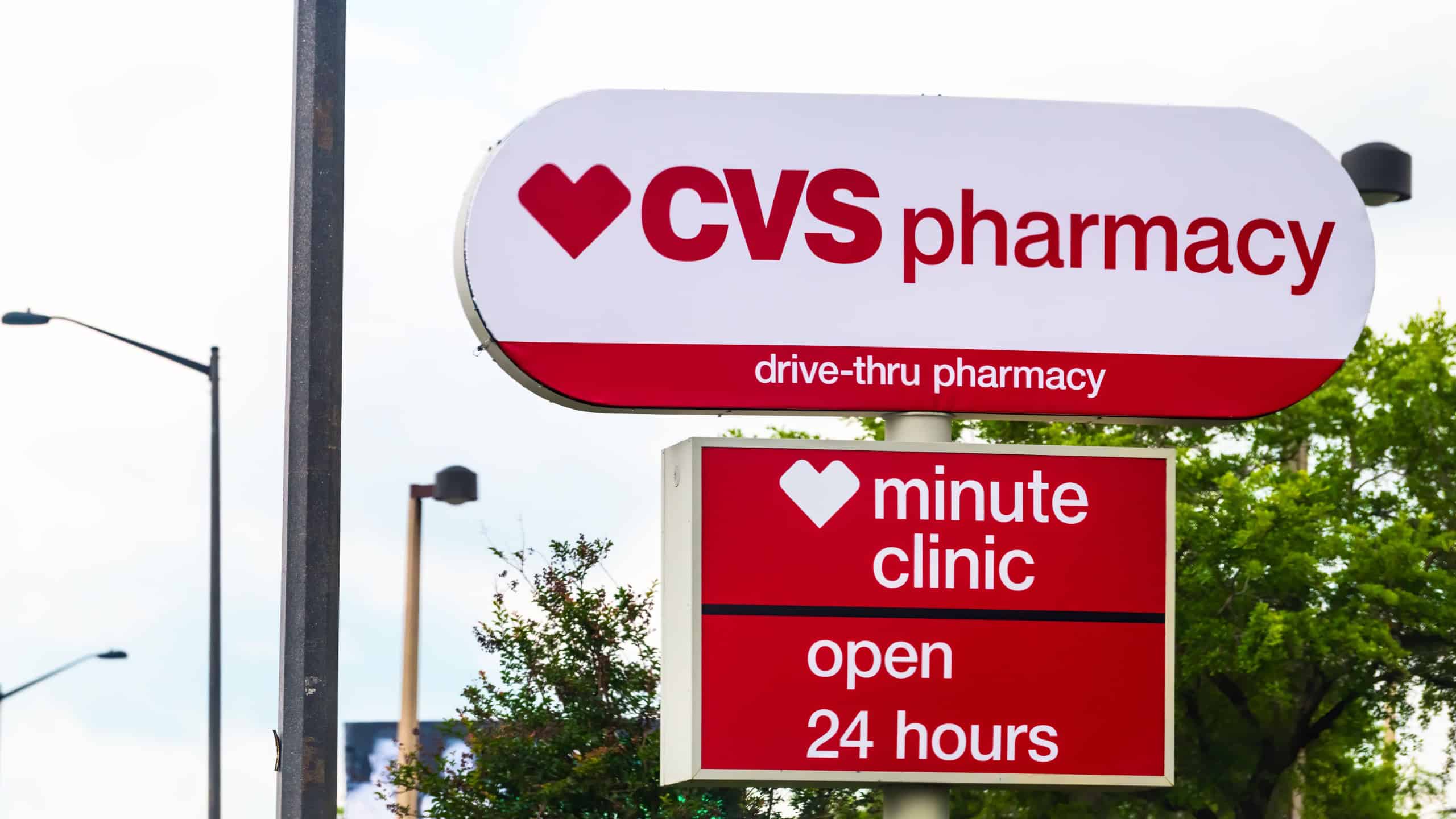 CVS Pharmacy store exterior entrance sign for drive-thru minute clinic open 24 hours with red logo