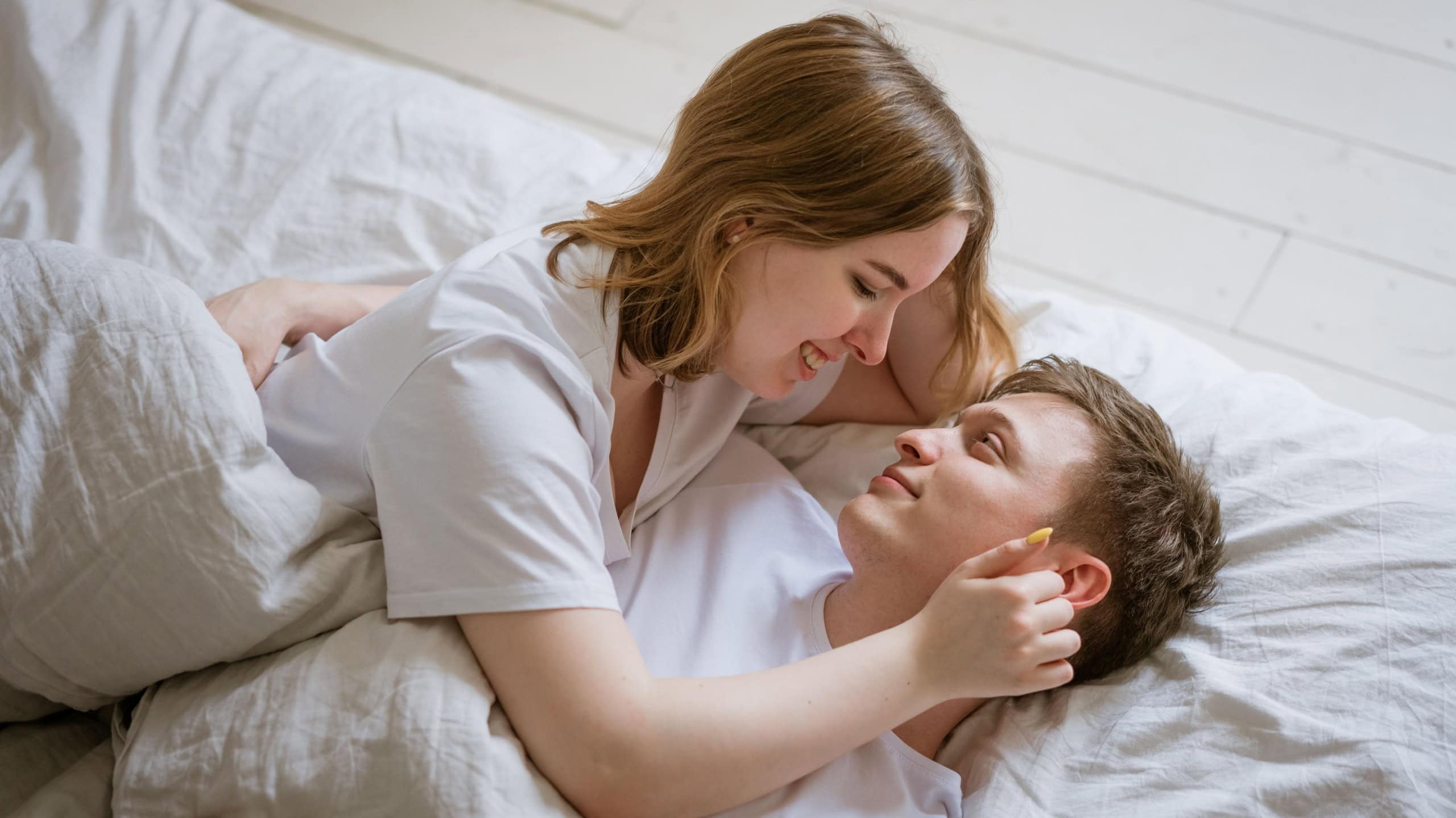 Happy romantic couple having sex young lovers during foreplay having tender and intimate moments in bed people, sexual, love and relationship concept