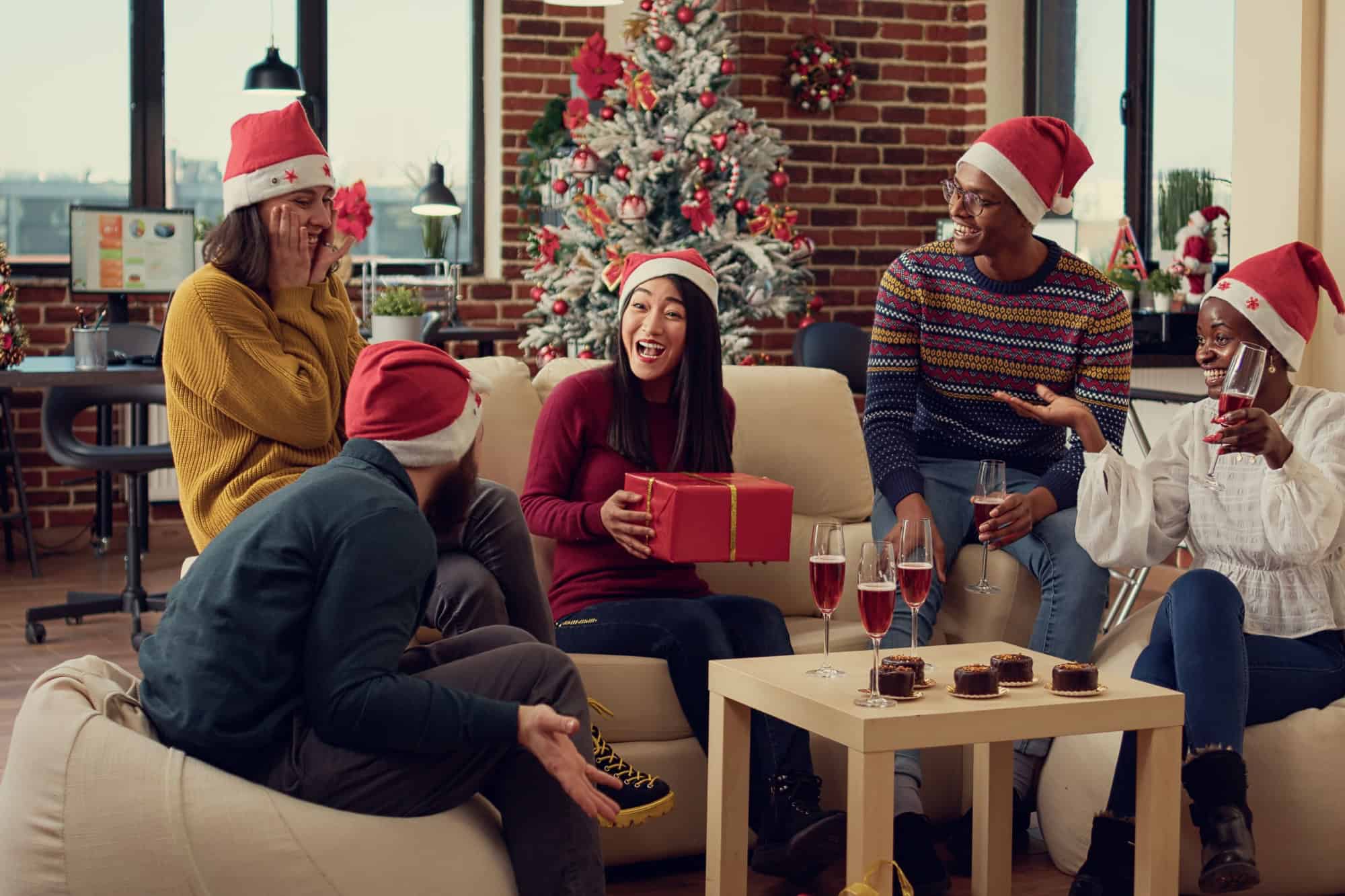 Diverse people exchanging presents at christmas party in office, celebrating holiday season together with xmas ornaments and lights. Making surprise gifts as seasonal winter tradition.