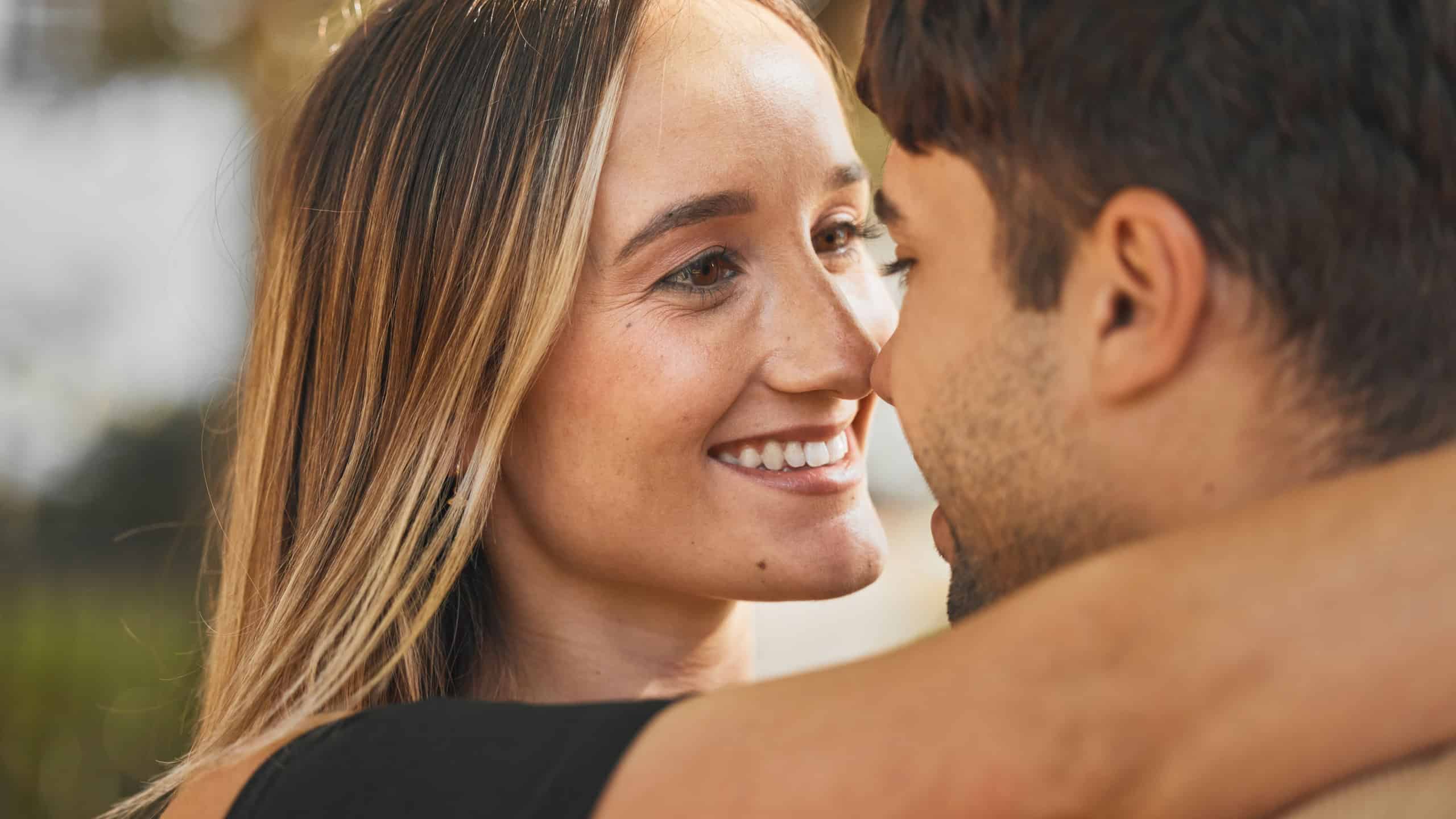 Love, couple and hug with kiss, smile and bonding together for relationship, marriage and happy. Romance, man and woman being intimate, embrace and romantic for happiness, connect and quality time.