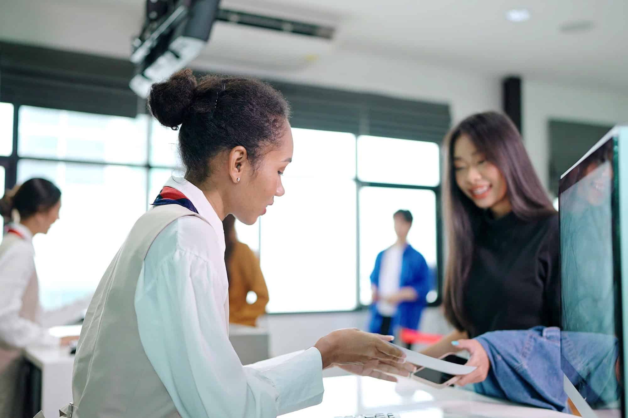 Asian passengers traveler giving boarding pass and passport to customer check in officer at service counter airport
