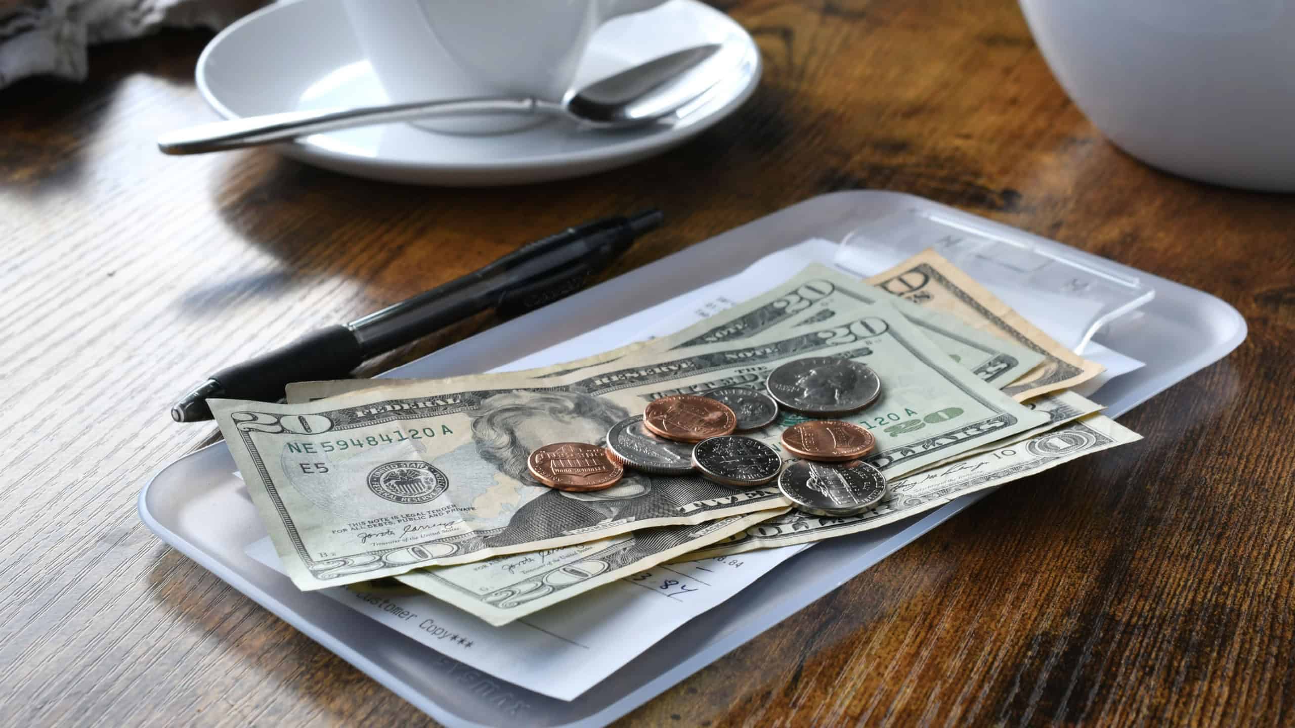 Paying for your bill tab at a restaurant cafe with cash money.