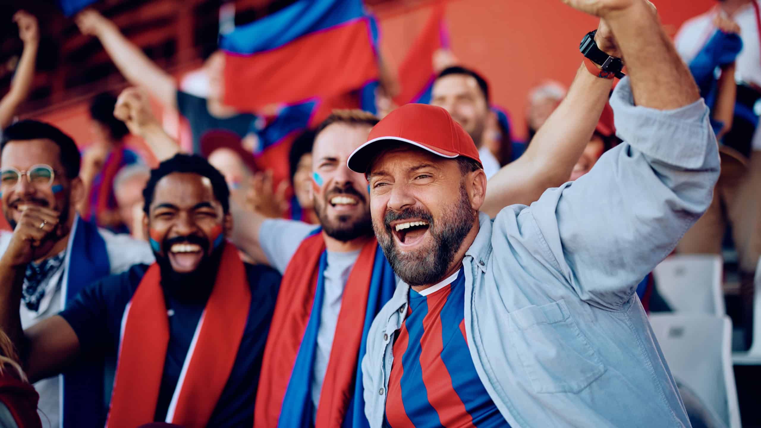 Senior Caucasian woman lying in hospital bed wearing oxygen tube, smiling at Black man healthcare worker taking notes on clipboard, medical monitoring device on finger, clinical setting