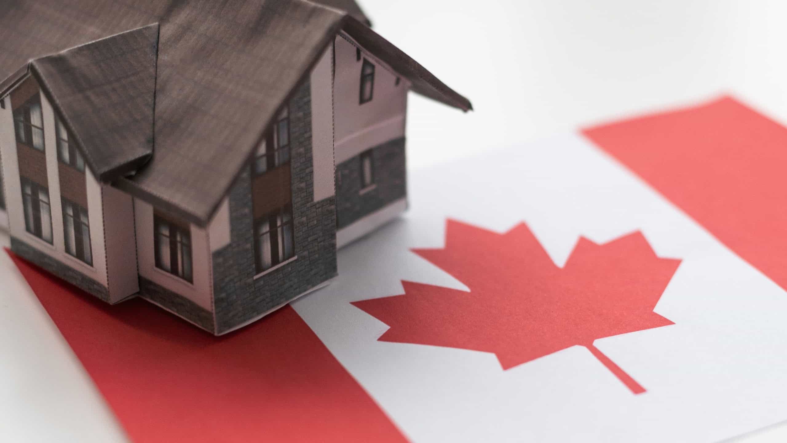 wooden house with flag of Canada Finance, investment, mortgage, loan and credit concept