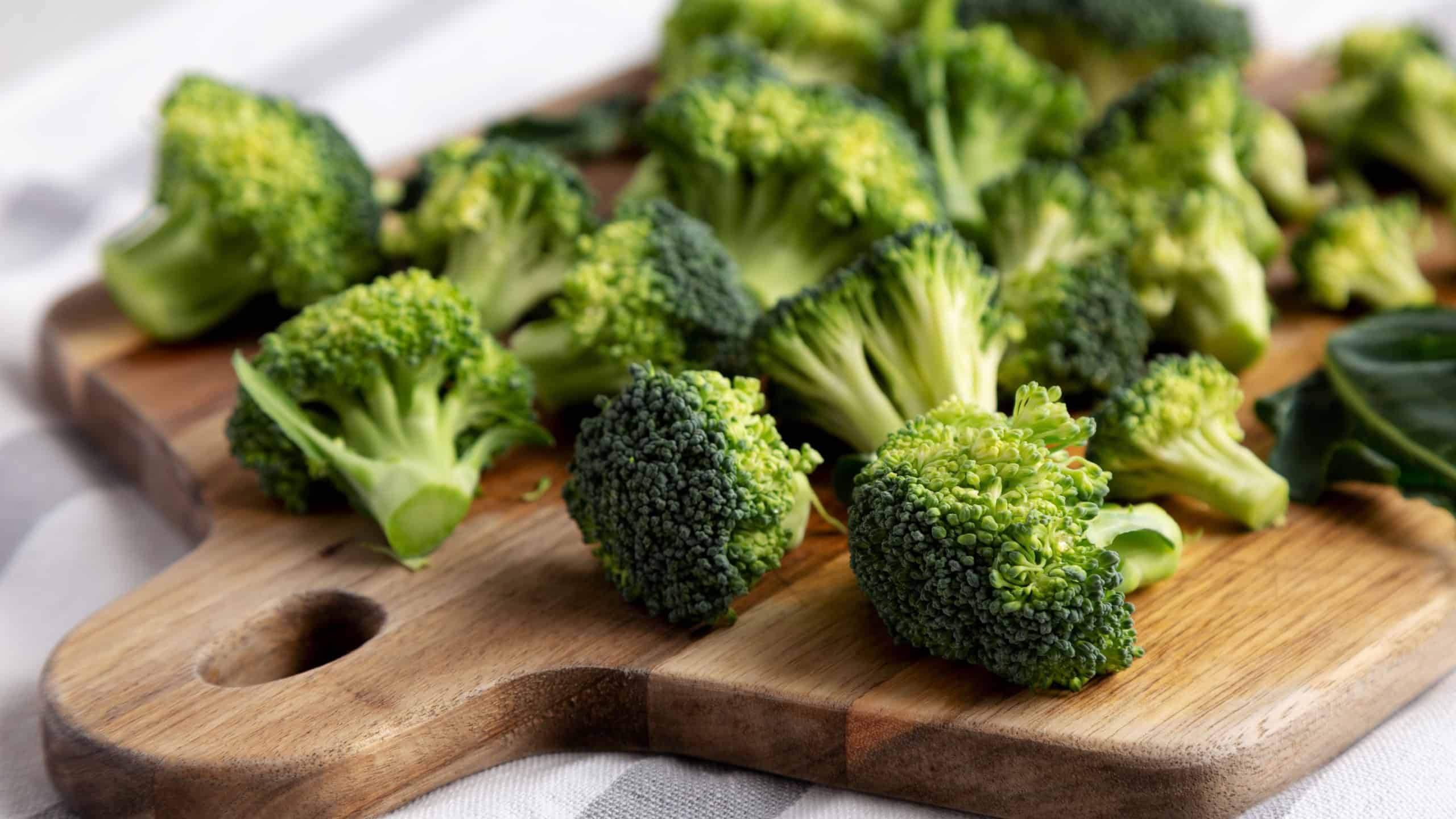 Organic Raw Broccoli Florets on a Wooden Board