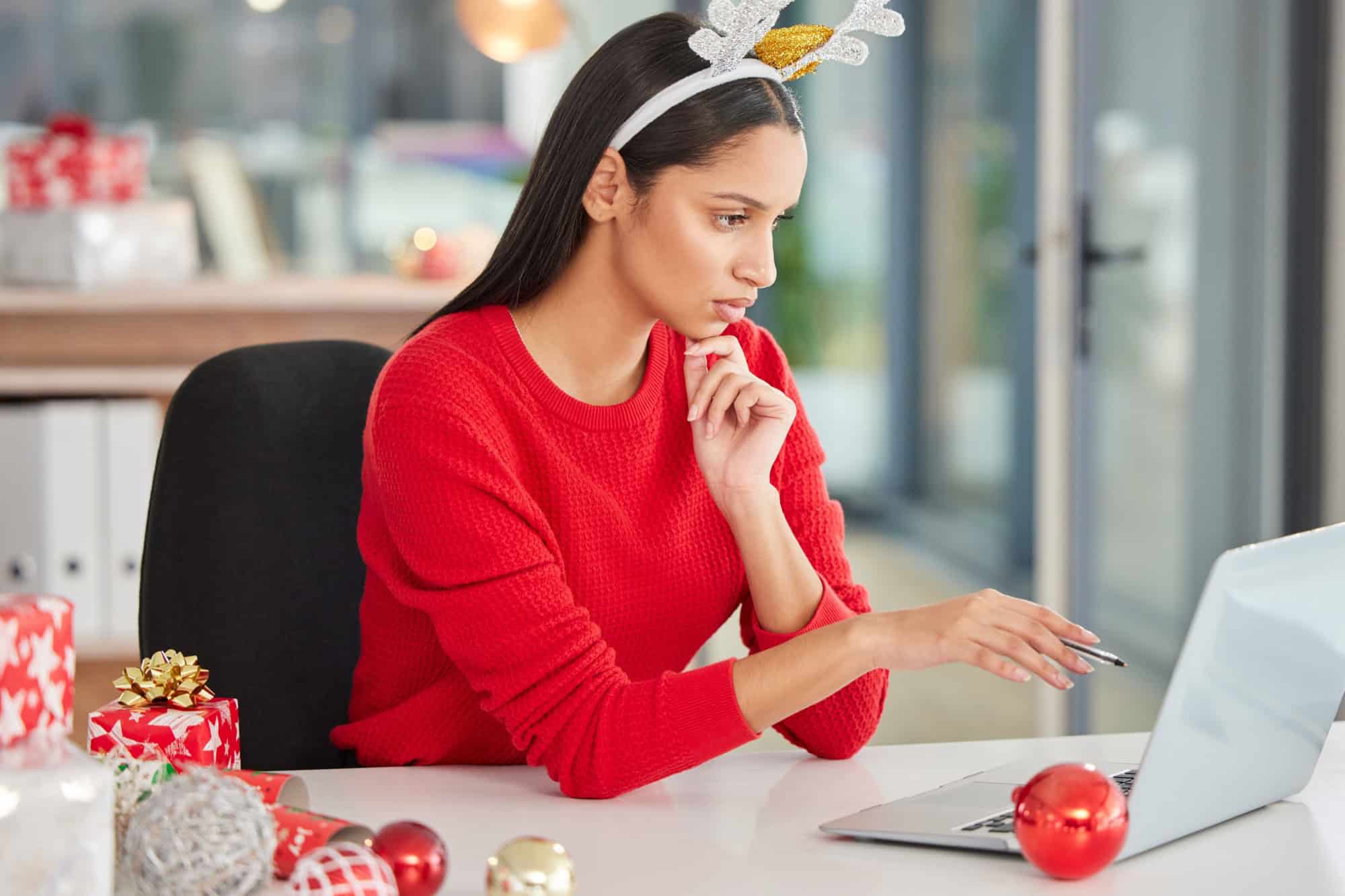 Office woman, Christmas and laptop with planning, ideas or thinking of gift giving for secret santa. Worker or copywriter reading or search on computer for copywriting newsletter on festive holiday