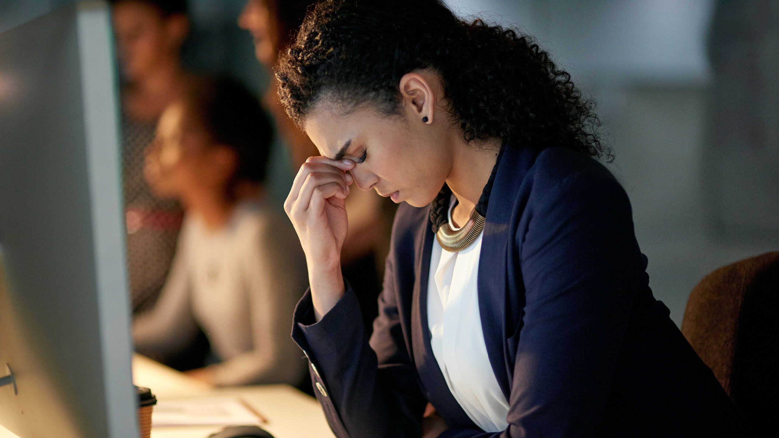 Woman, desk and stress in office with headache, fatigue and overworked in workplace. Burnout, computer or brain fog for financial manager person, migraine pain and technology for frustrated employee