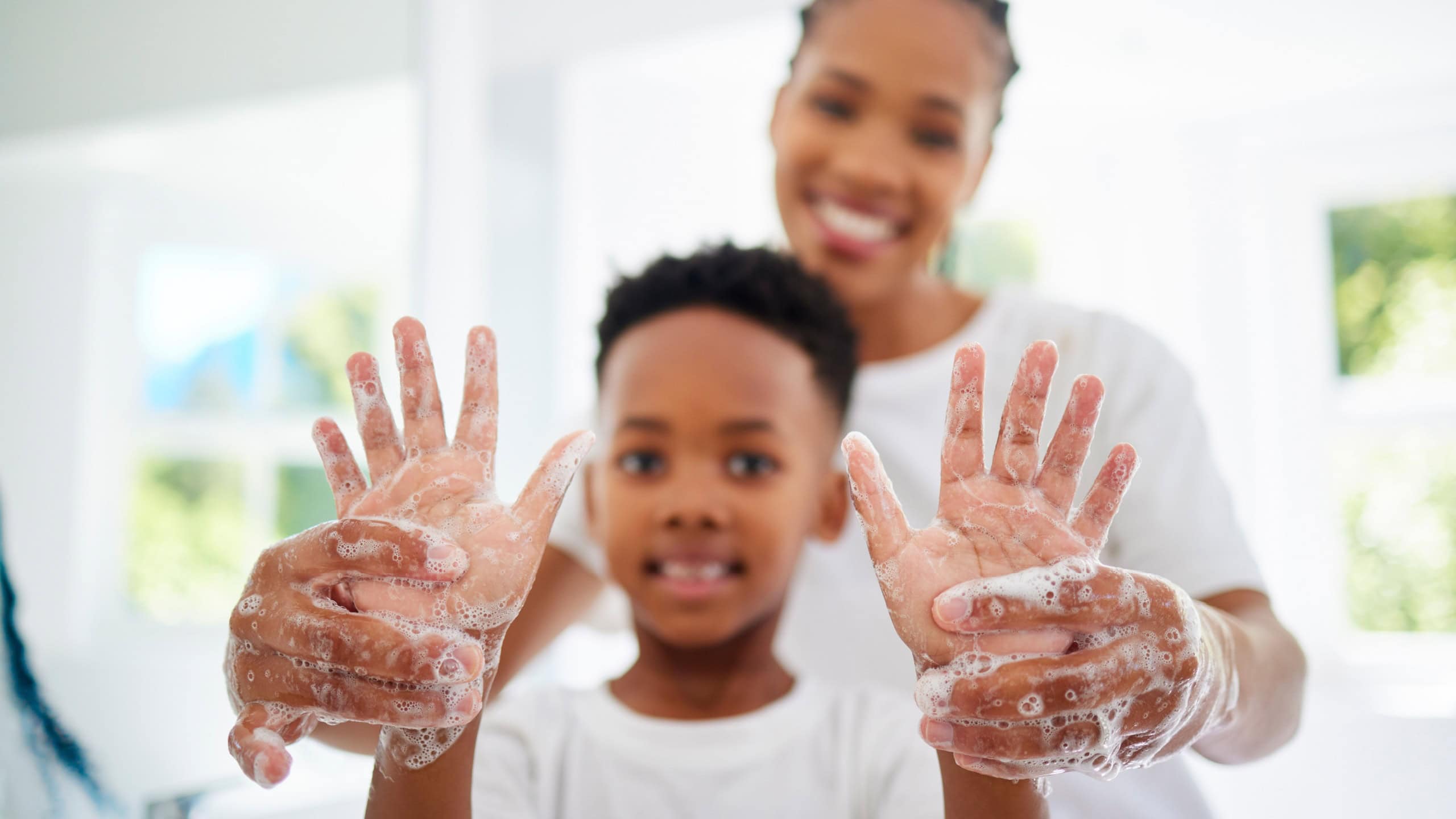 Black mom, boy and smile for hands with soap in home for hygiene, care and support with child development. Parent, kid and happy or excited on portrait with handwashing for germs and bacteria