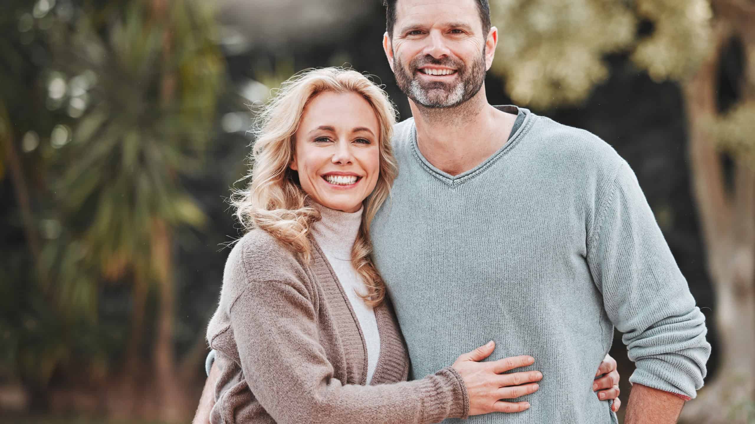 Mature couple, portrait and garden hug for support, love and affection for spouse on holiday. Happy people, trust and vacation for bonding on travel, embrace and countryside security in commitment