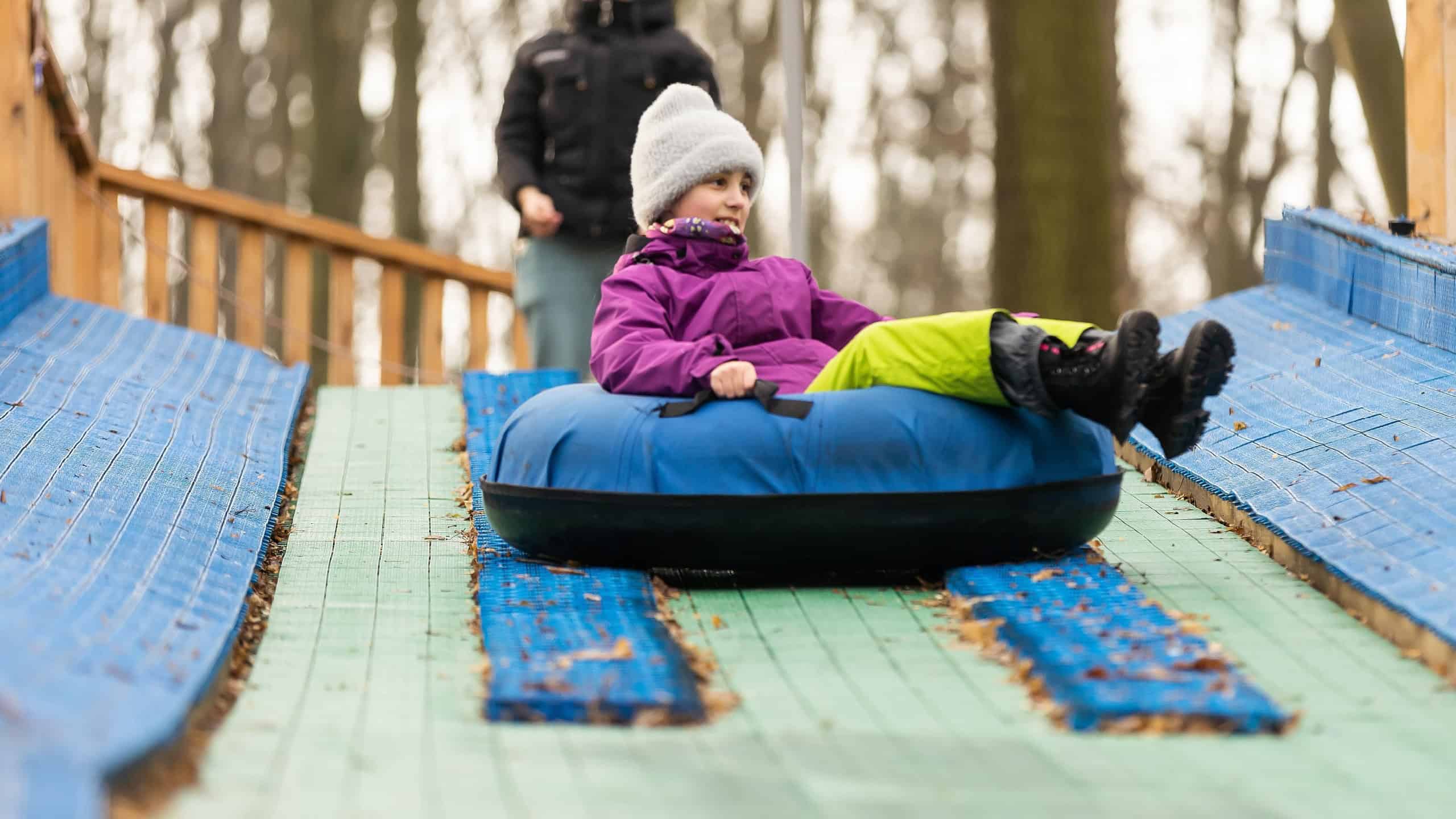 a little kid enjoying tubing down the wavy track ski resort